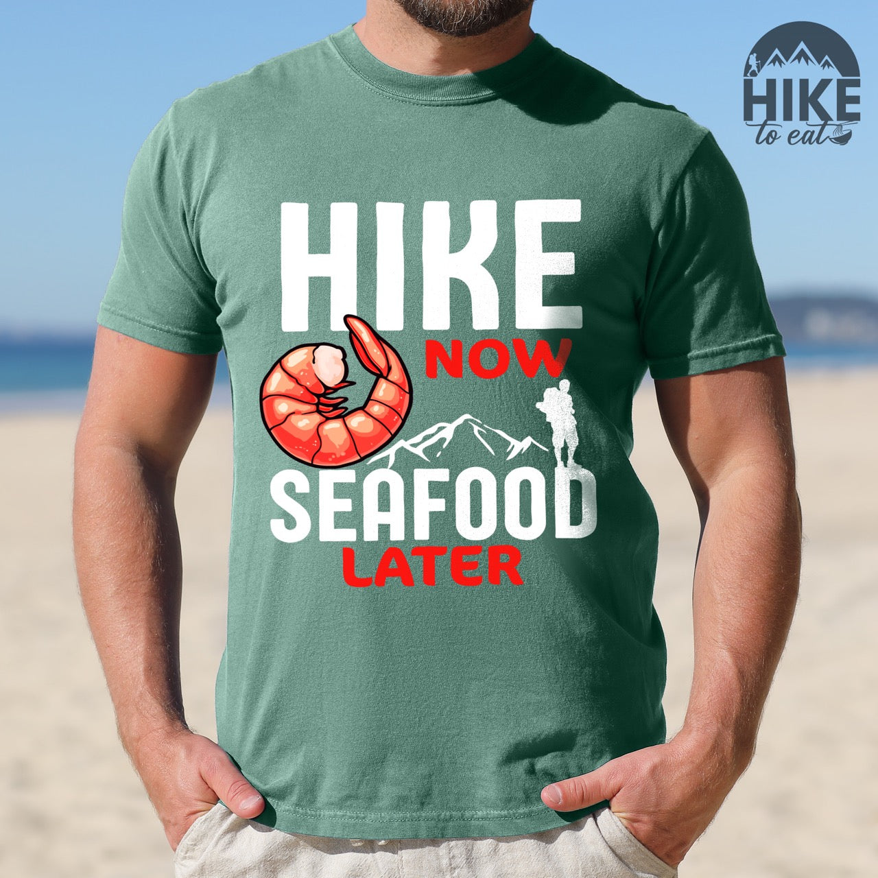Man wearing the funny hiking motivation shirt for seafood lovers featuring bold NOW LATER typography, realistic shrimp graphic, mountain landscape illustration, and hiker silhouette on premium outdoor adventure tee perfect gift for trail enthusiasts who love fresh ocean food in light green