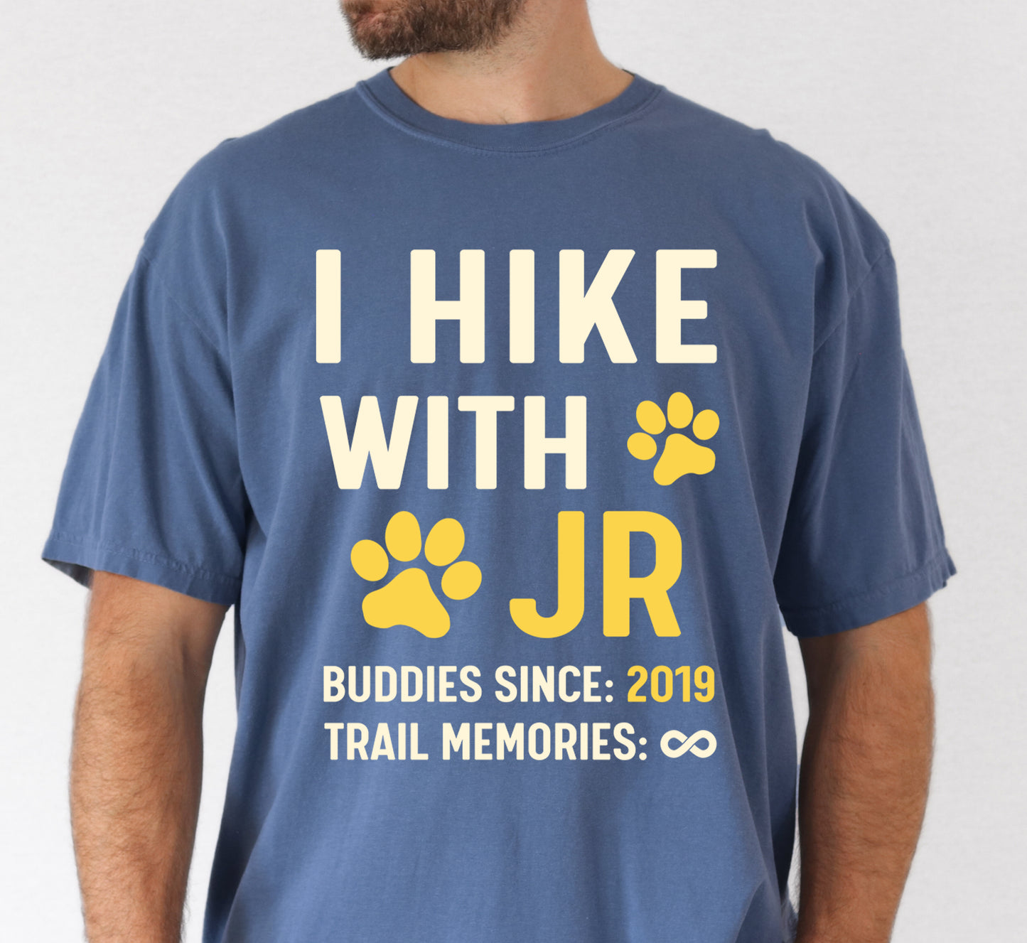 Blue Jean (Denim Blue) graphic t-shirt with 'Trail Buddies Personalized' design featuring 'I Hike with' text and customizable pet name field in cream and yellow lettering with paw prints, plus customizable year for 'buddies since' and trail memories infinity.