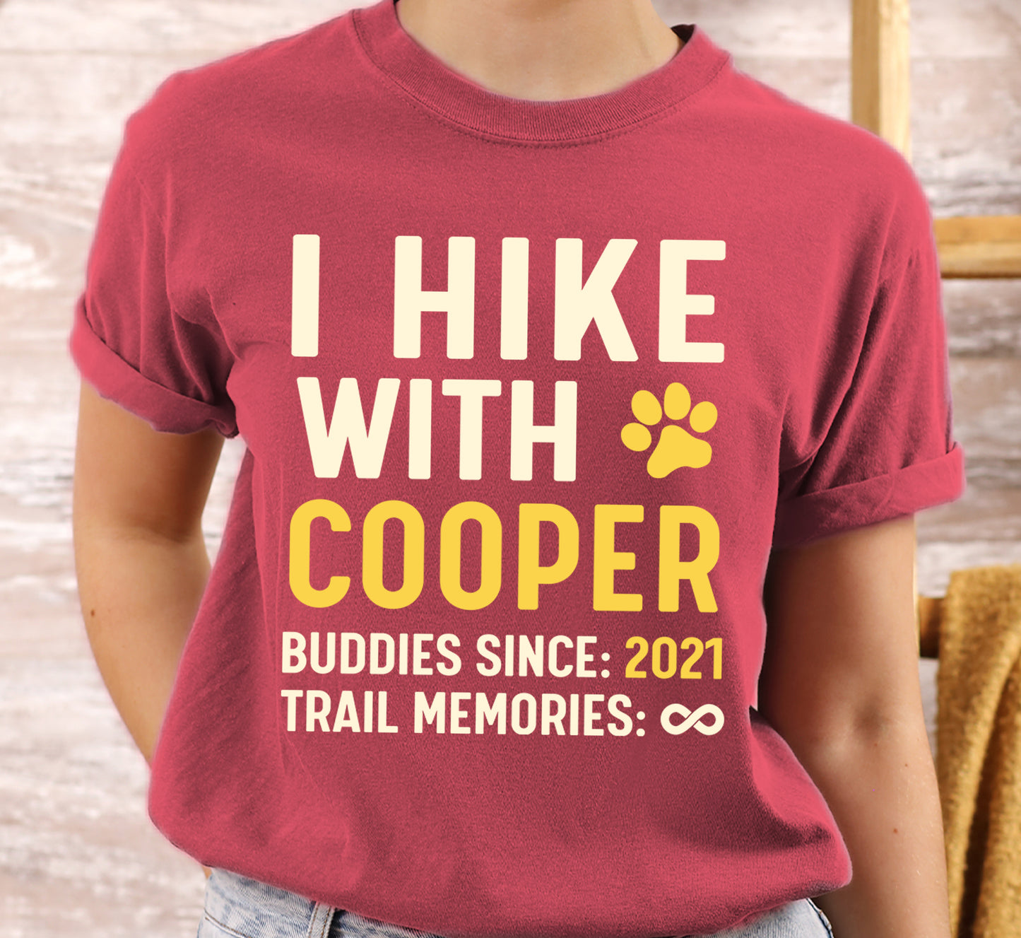 Crimson (Dark Pink) graphic t-shirt with 'Trail Buddies Personalized' design featuring 'I Hike with' text and customizable pet name field in cream and yellow lettering with paw prints, plus customizable year for 'buddies since' and trail memories infinity.