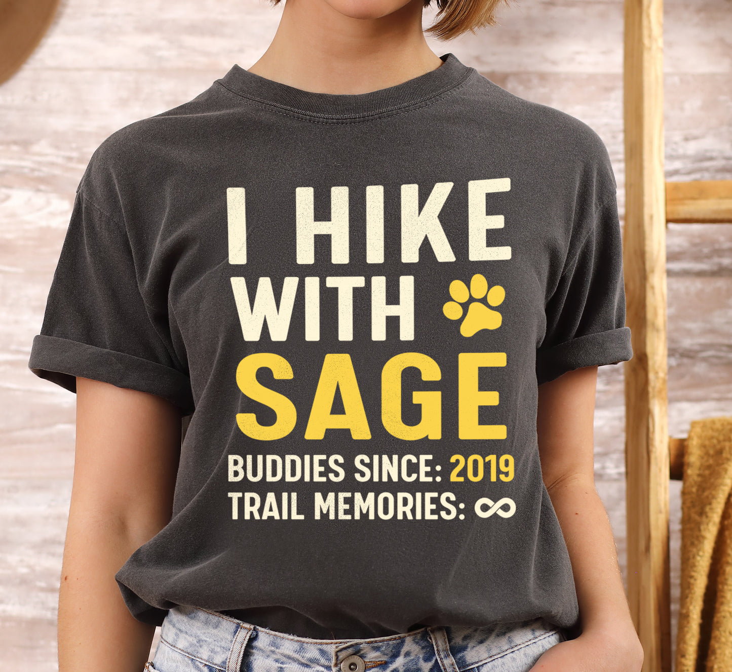 Pepper (Dark Gray) graphic t-shirt with 'Trail Buddies Personalized' design featuring 'I Hike with' text and customizable pet name field in cream and yellow lettering with paw prints, plus customizable year for 'buddies since' and trail memories infinity.