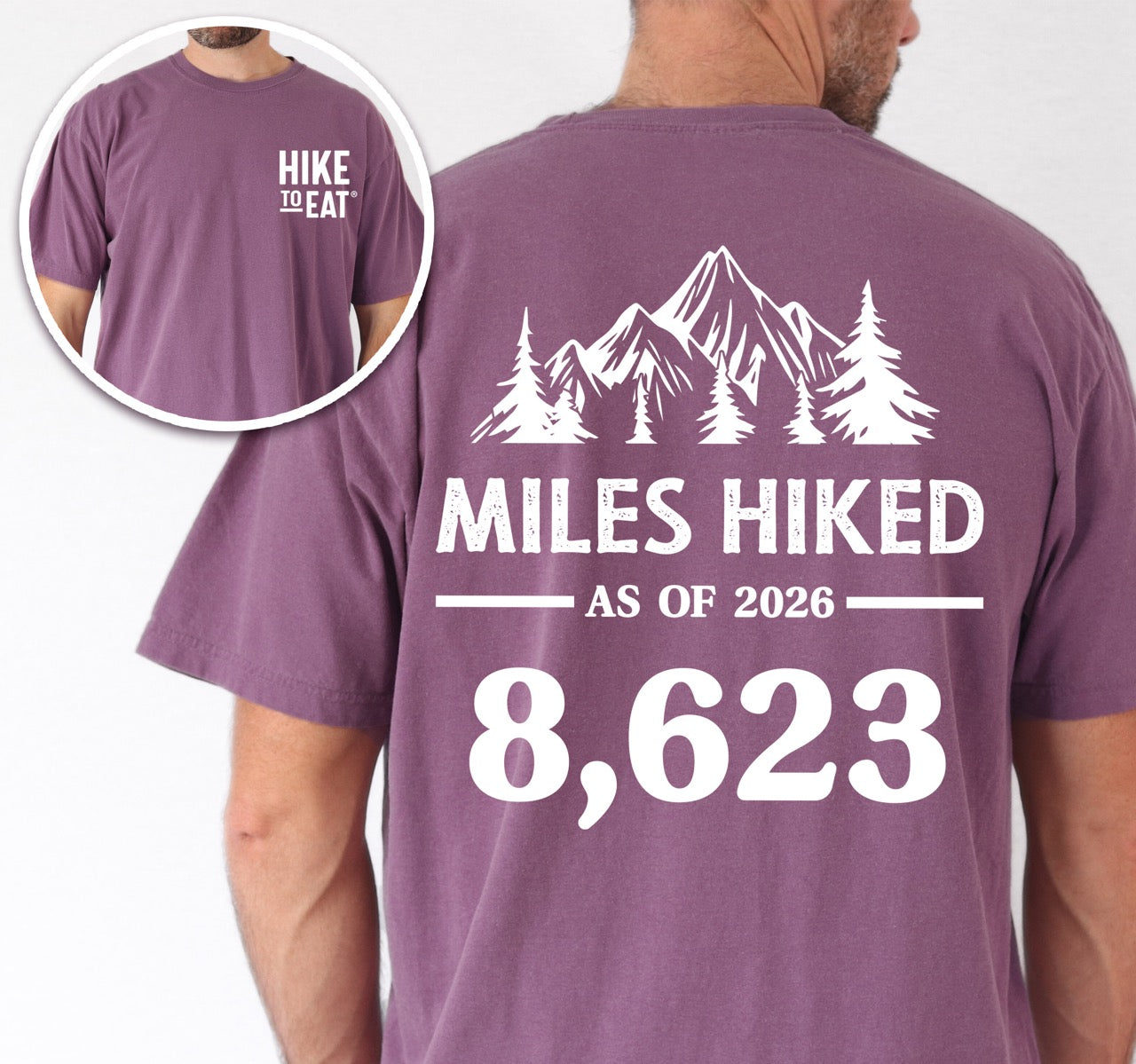 Man wearing Berry (purple) t-shirt with Hike to Eat logo on front chest, back featuring MILES HIKED AS OF 2026 text with personalized number field, mountain and pine tree silhouettes, customizable achievement tracker design - perfect for hikers.