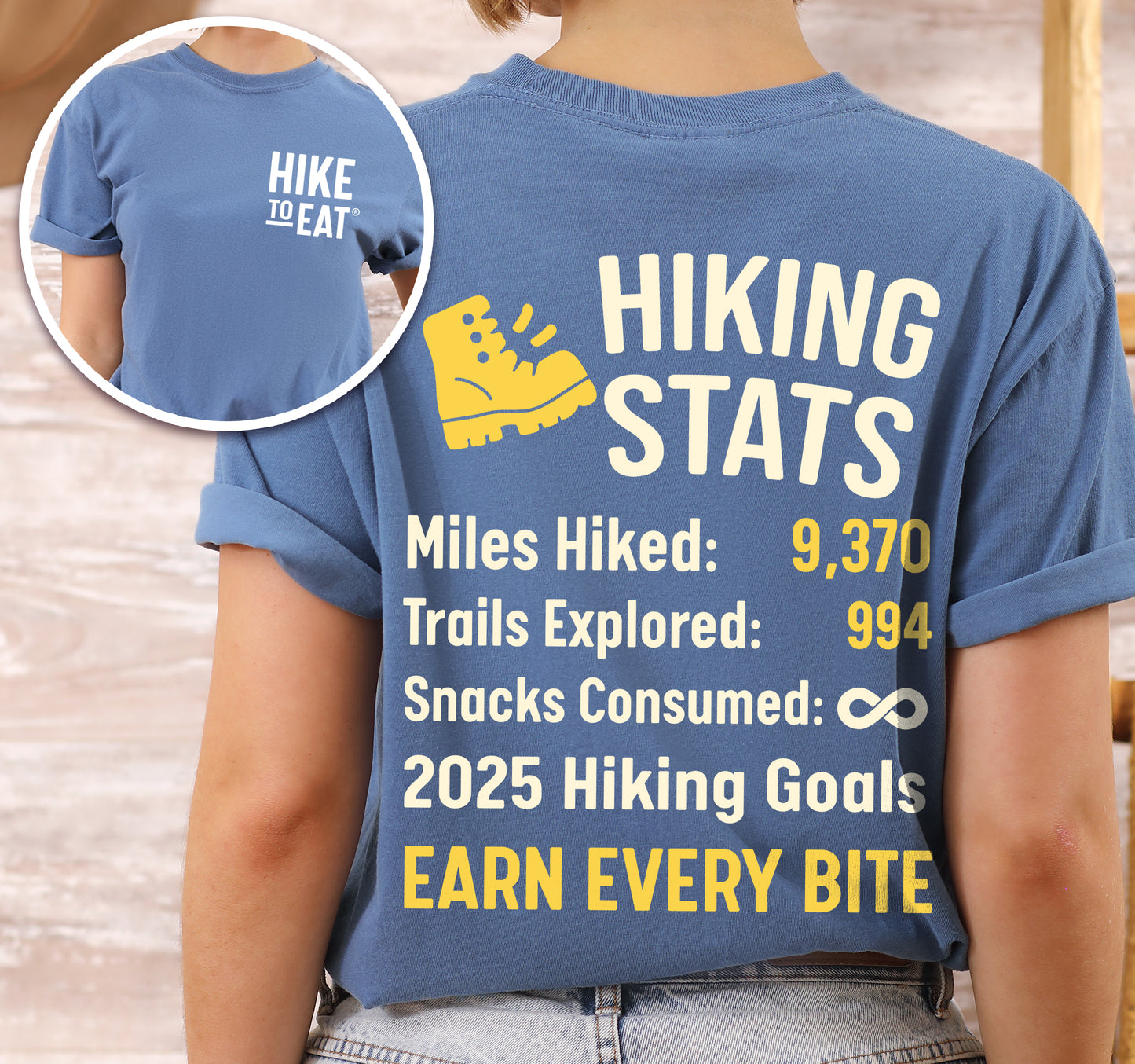 Blue Jean (Denim Blue) Hike to Eat t-shirt front and back view showing small white chest detail and large back design featuring 'Trail & Snacks Hiking Stats Personalized' with yellow hiking boot icon, customizable miles hiked and trails explored numbers, snacks consumed infinity, and 2025 hiking goals.