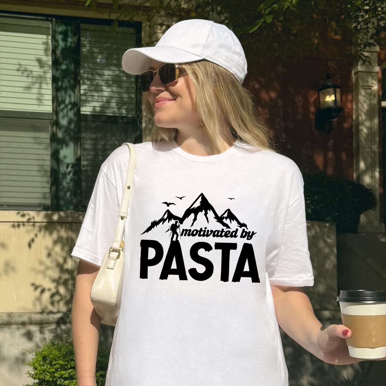 woman wearing white motivated by Pasta statement tee with mountains, birds, and hiker silhouette for pasta enthusiasts and hikers