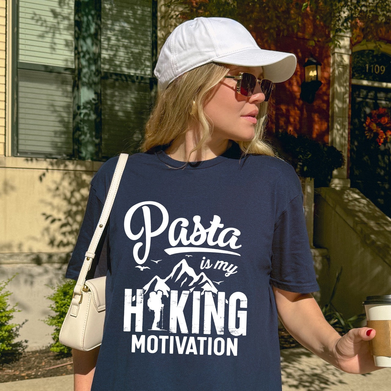 woman wearing blue Pasta is my Hiking Motivation statement tee with script typography, mountains, birds, and backpacker for pasta lovers