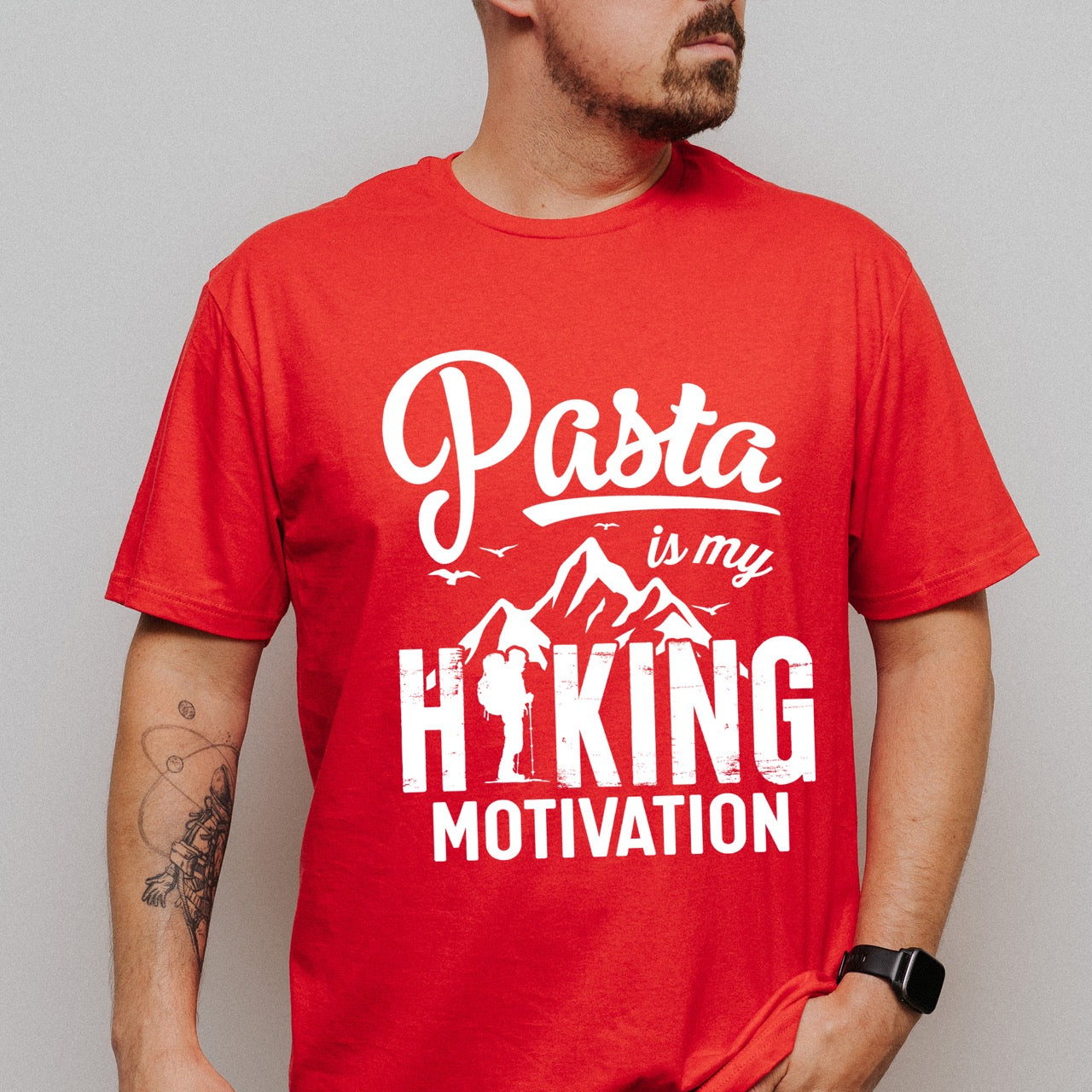 man wearing red Pasta is my Hiking Motivation statement tee with script typography, mountains, birds, and backpacker for pasta lovers