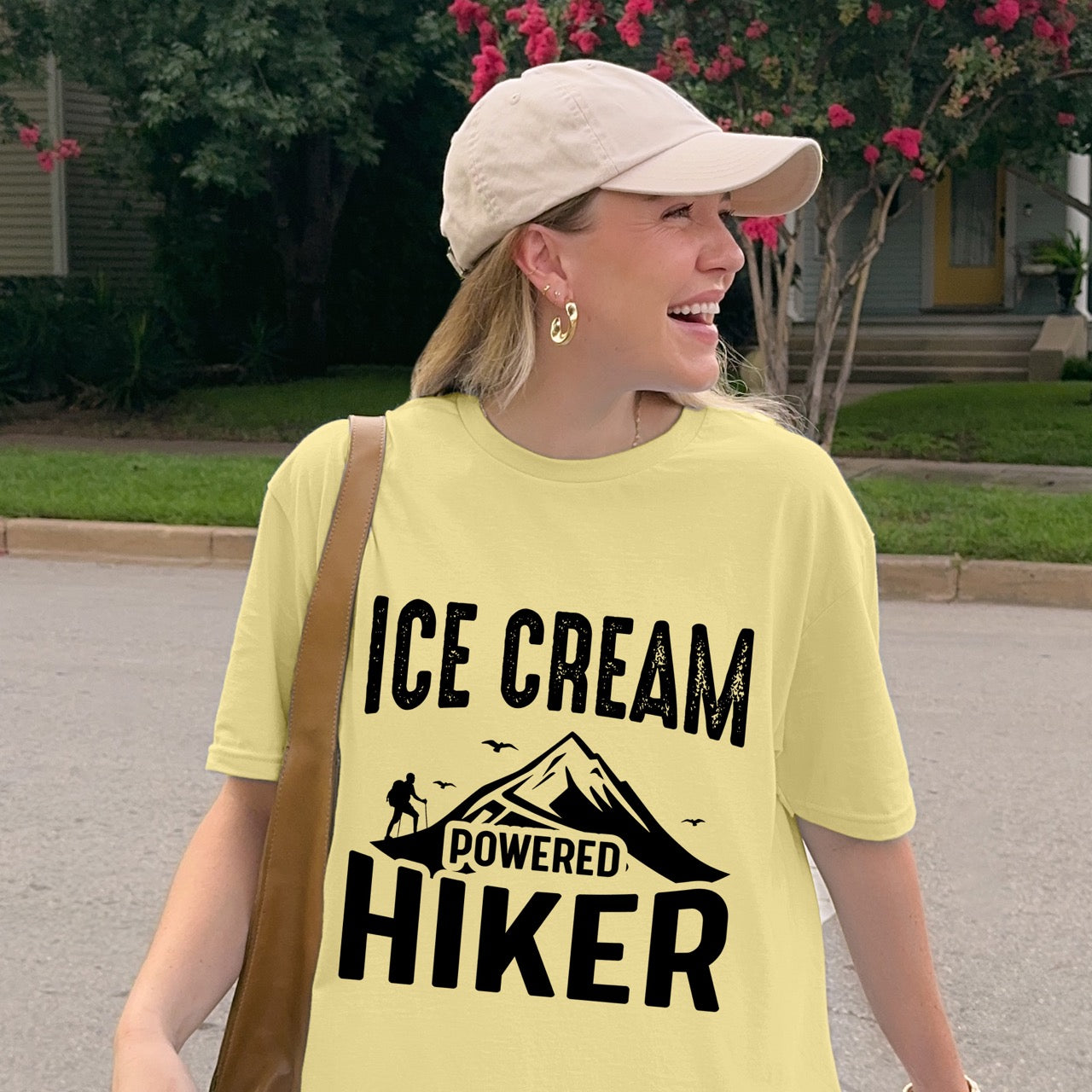 Woman wearing Cornsilk color (yellow) Ice Cream Powered Hiker statement tee with bold distressed typography, mountain peaks, hiker silhouette, and flying birds for dessert-loving outdoor enthusiasts, hikers and foodies