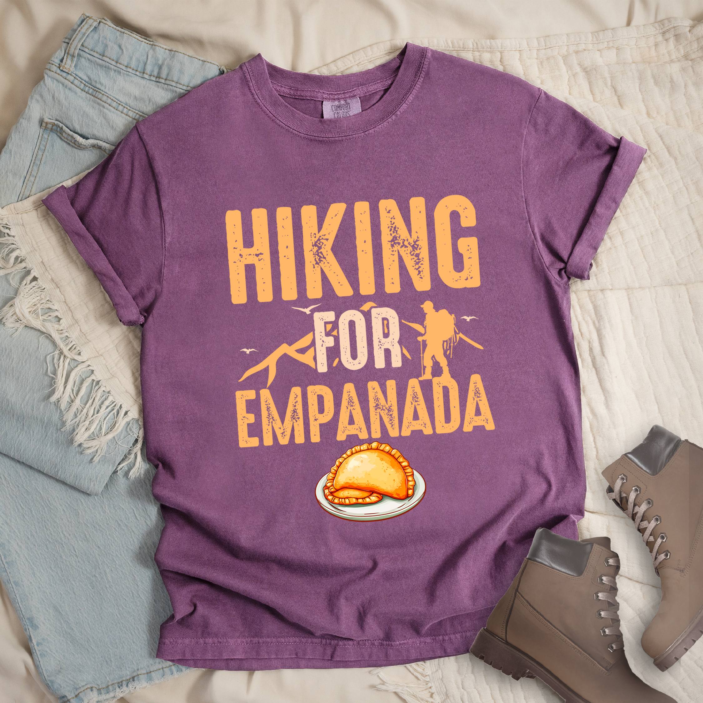 Dark pink shirt with Hiking Design featuring the phrase “Hiking for Empanada” and a hiker silhouette with mountains and a plate of empanada.