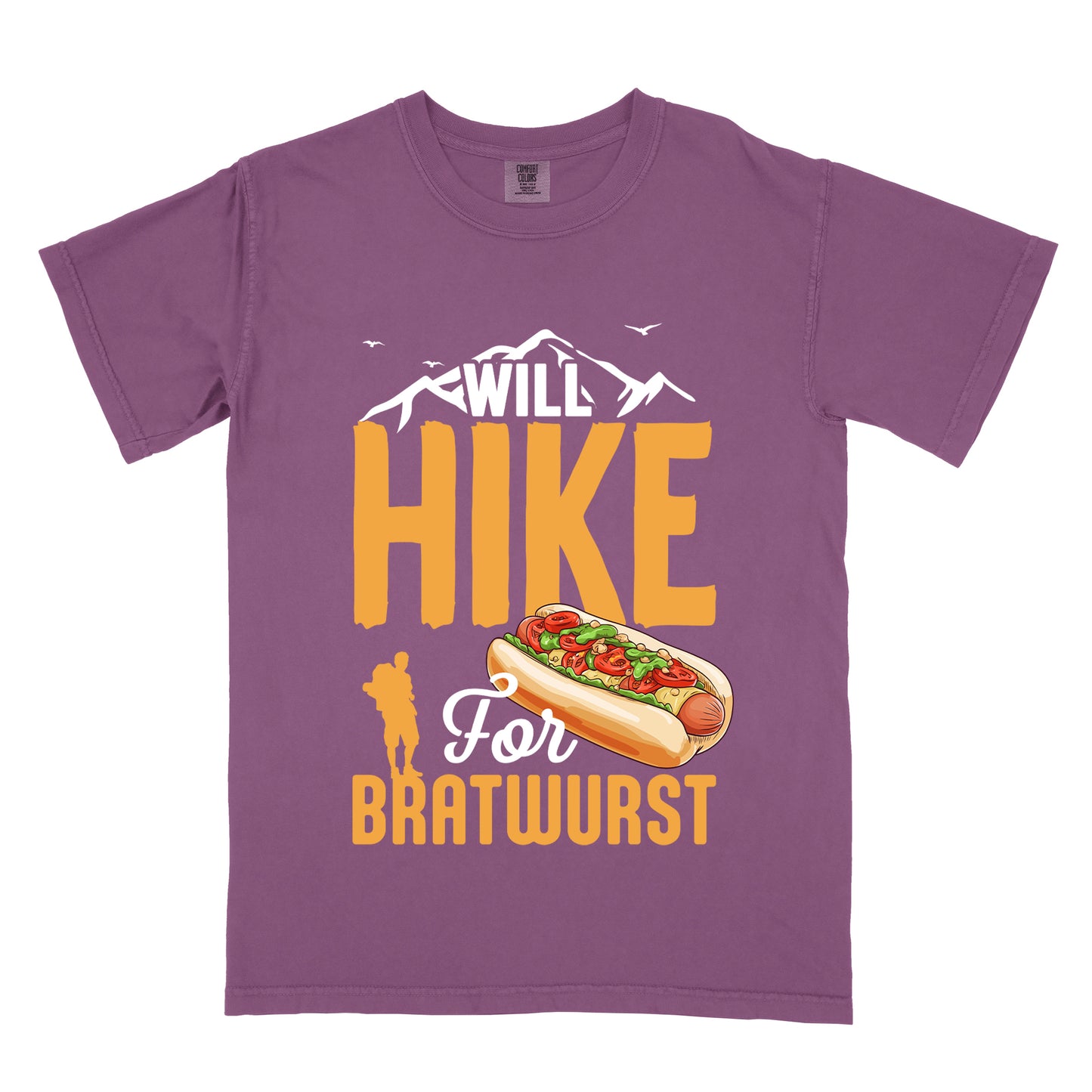 Berry (Dark Violet) t-shirt with white, golden orange, and white text reading "WILL HIKE For BRATWURST". "WILL" appears in white text integrated with mountain outlines at the top, "HIKE" in large golden orange letters in the middle, "For" in white script below it, and "BRATWURST" in golden orange at the bottom. Features an illustration of a bratwurst in a bun with toppings to the right of "For" and a golden orange silhouette of a hiker to the left of "BRATWURST". Small white birds fly near the mountains.
