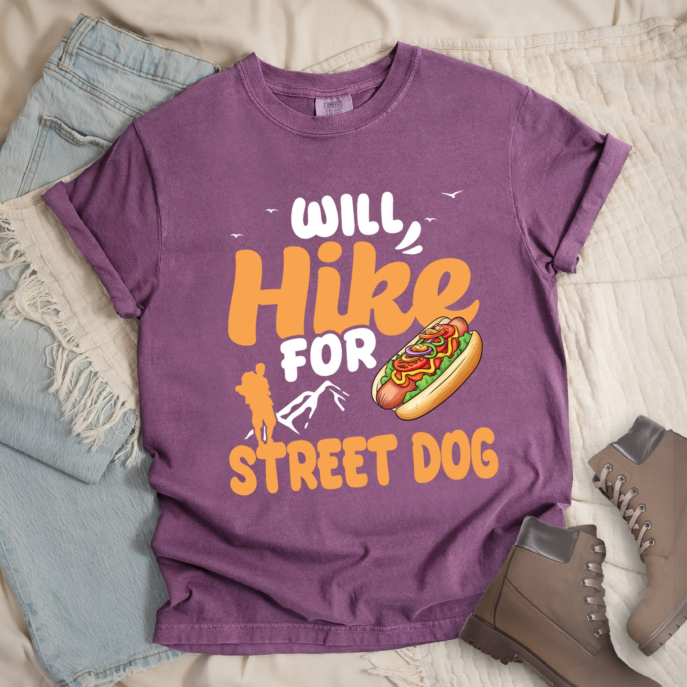 Dark pink shirt with Hiking Design featuring the phrase “Will Hike for Street Dog” and an illustration of a hot dog with toppings.