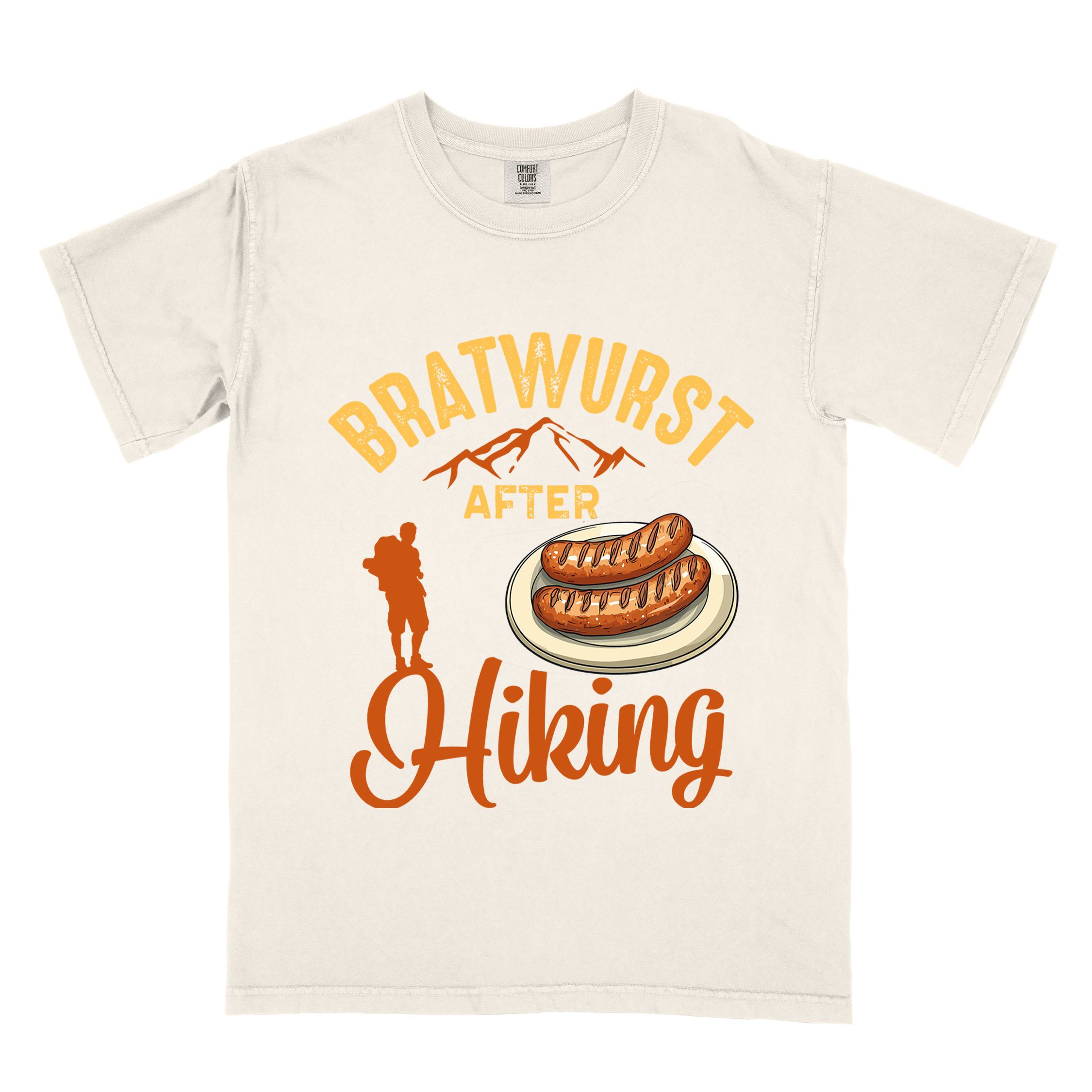 Ivory "bratwurst after hiking" colored vintage tee with bold typography, illustrated bratwurst on a plate, mountains, birds, and backpackers for street food enthusiasts.