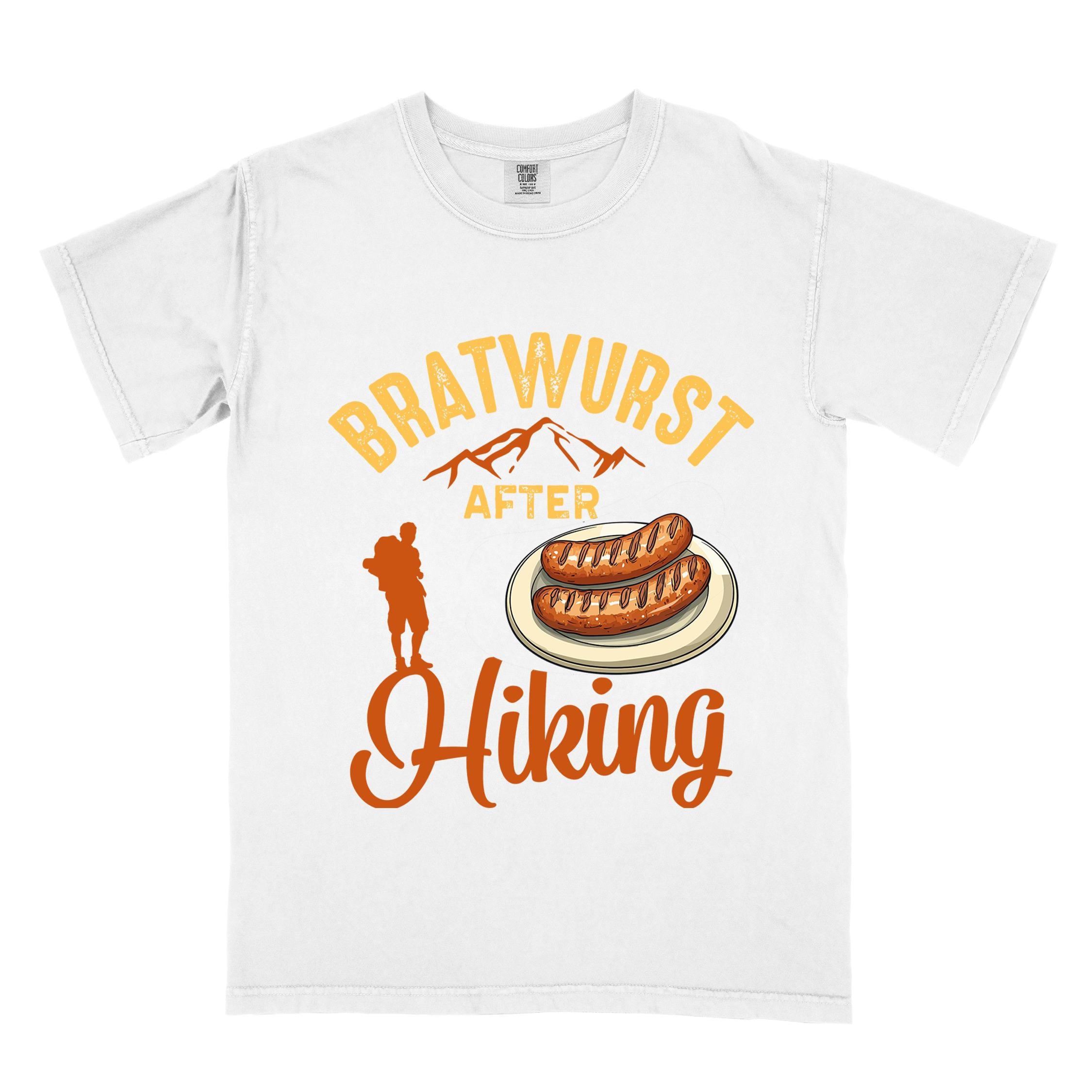 White "bratwurst after hiking" colored vintage tee with bold typography, illustrated bratwurst on a plate, mountains, birds, and backpackers for street food enthusiasts.