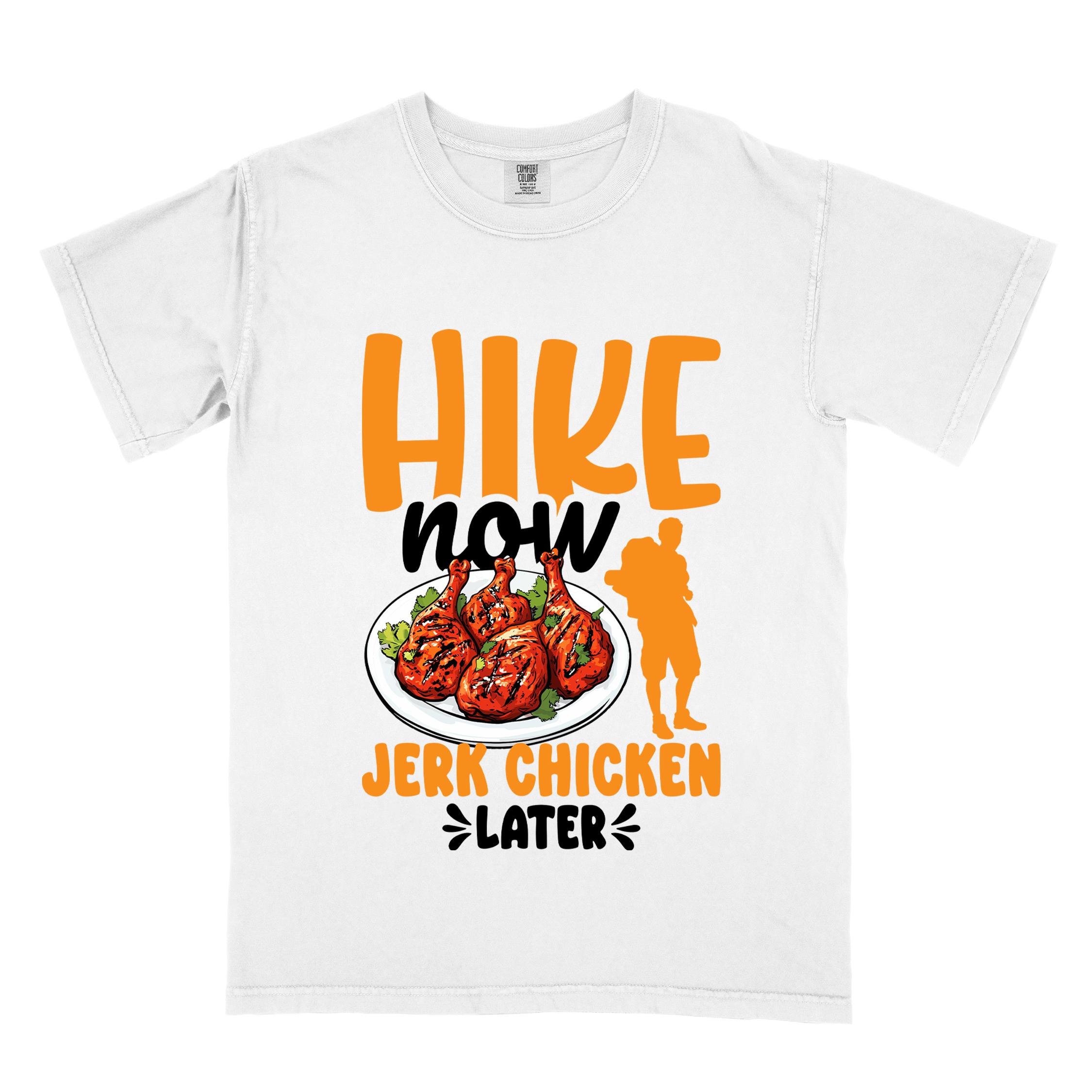 White "hike now jerk chicken later" colored vintage tee with bold typography, illustrated jerk chicken on a plate, mountains, birds, and backpackers for bbq chicken lovers.
