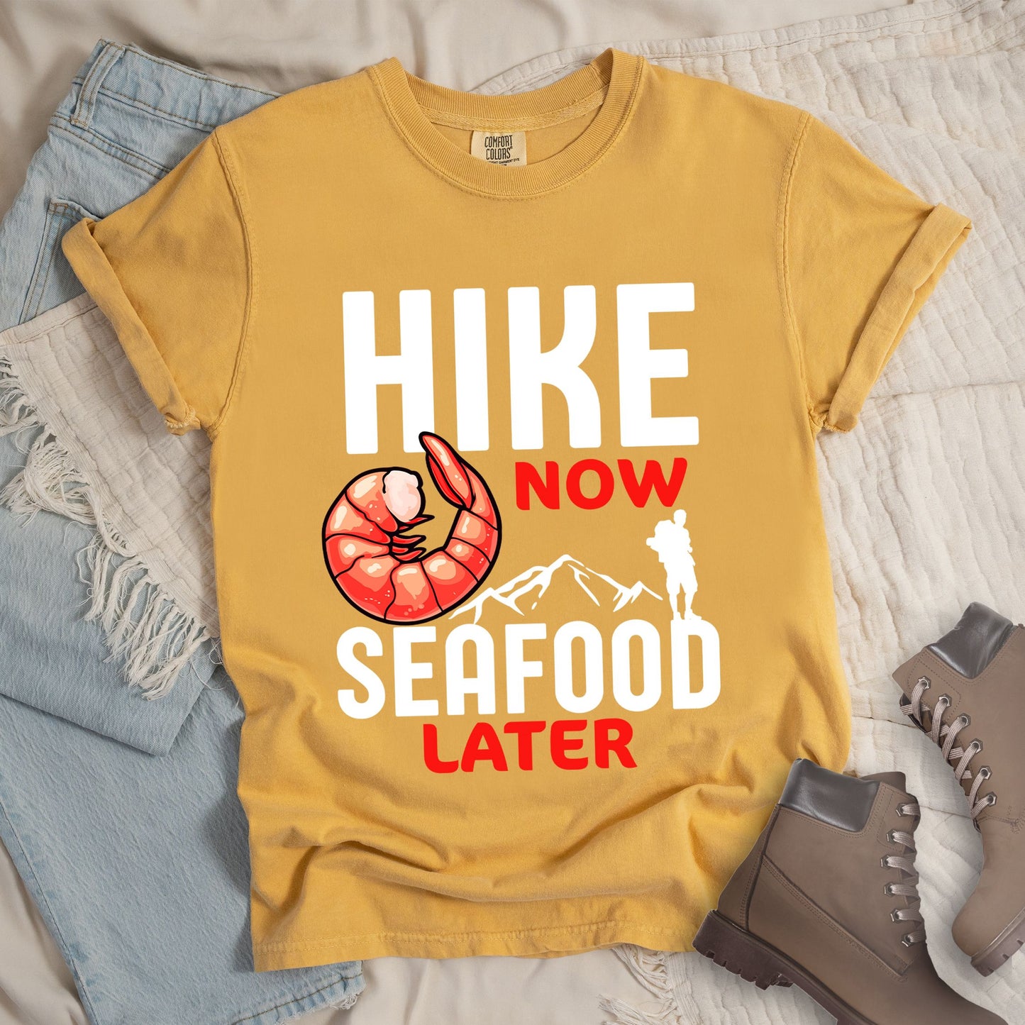 Yellow shirt with Hiking Design featuring the phrase “Hike Now Seafood Later” and an illustration of a shrimp with a mountain outline.