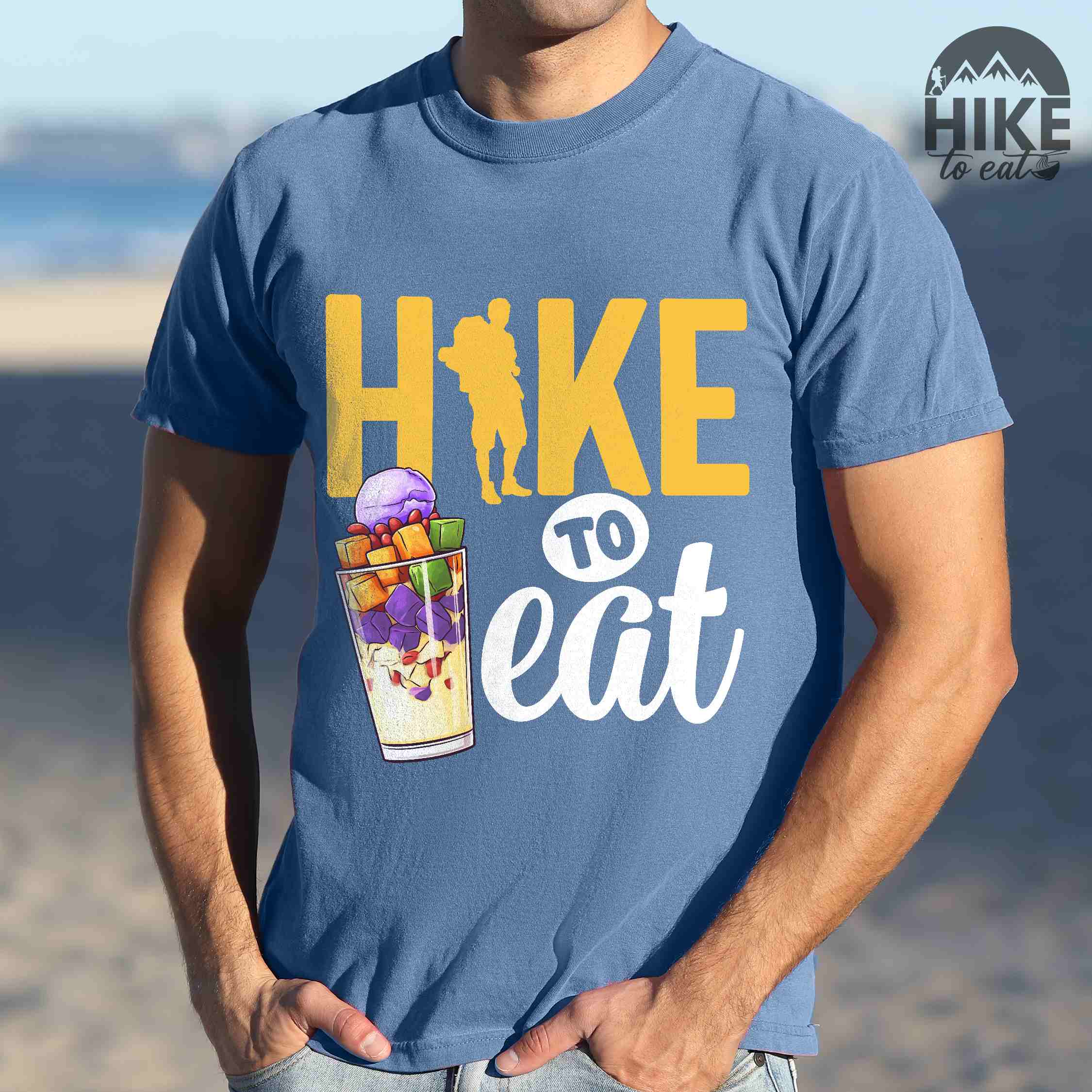 Man wearing blue jean "hike to eat" colored vintage tee with bold typography, illustrated halo-halo dessert, and backpackers for iced dessert lovers.