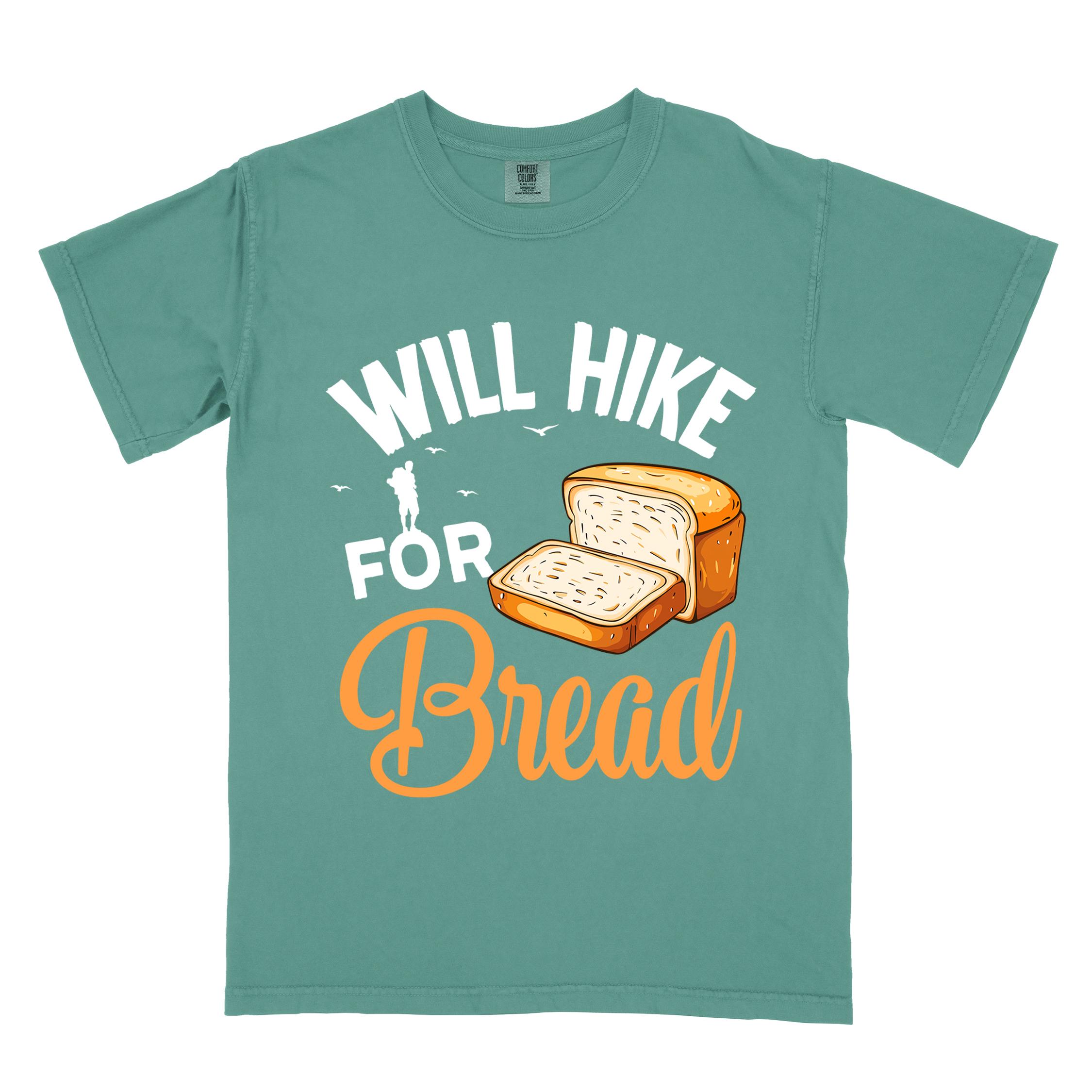 Light green "Will hike for bread" colored statement tee with flowing script typography, bold lettering, and loaf of bread illustration for pastry-loving outdoor enthusiasts, hikers and foodies