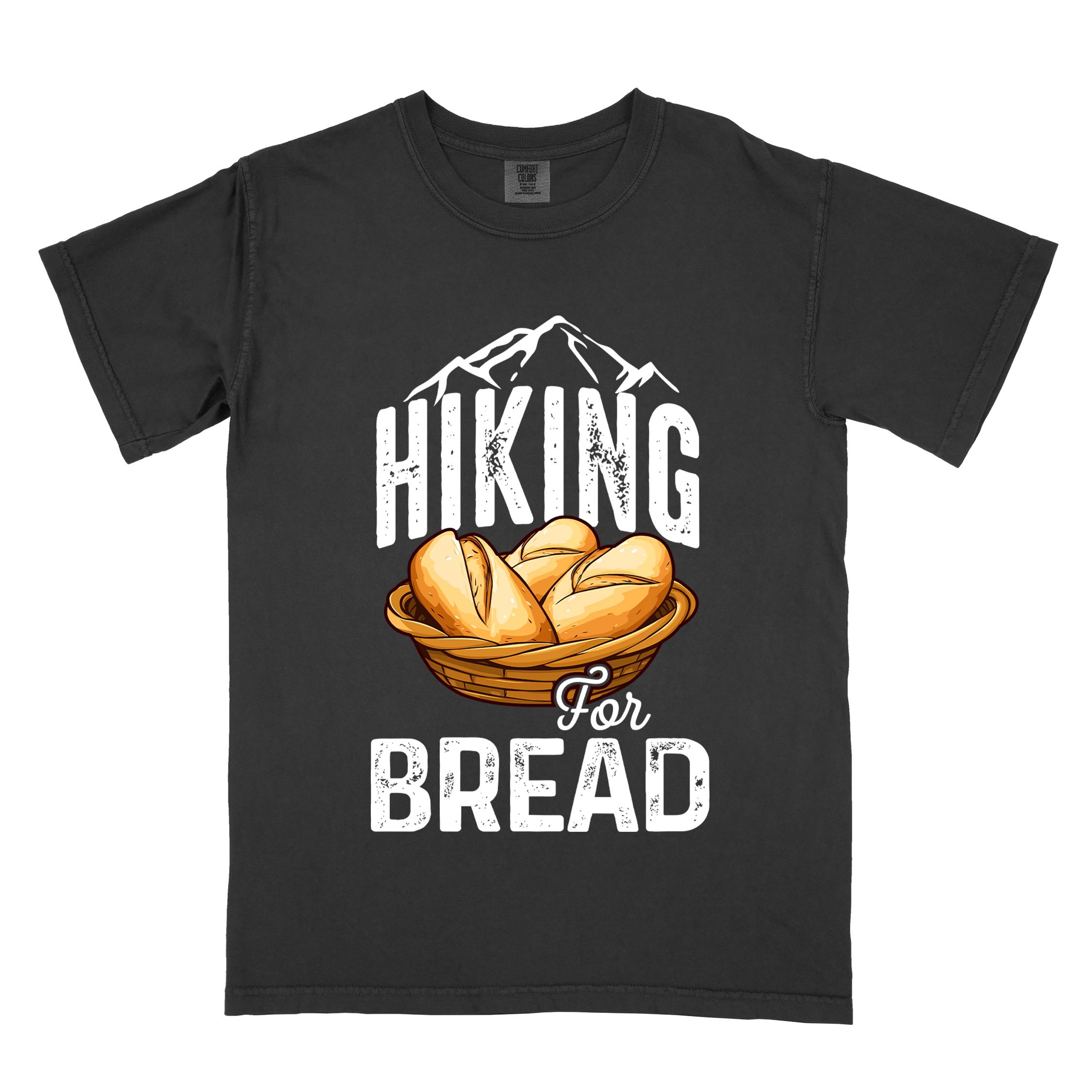 Black "Hiking for bread" colored statement tee with flowing script typography, bold lettering, and freshly baked bread illustration for pastry-loving outdoor enthusiasts, hikers and foodies