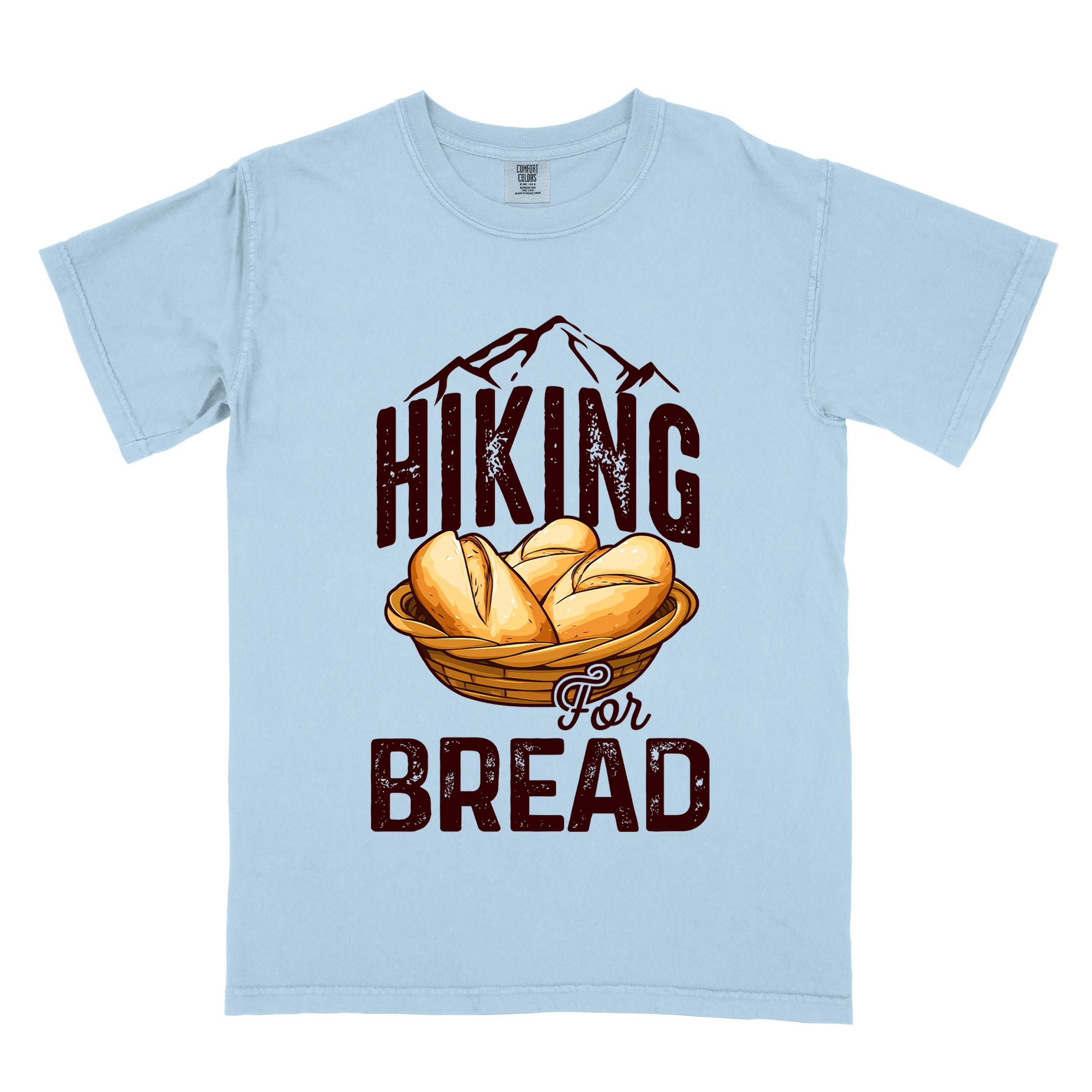 Chambray "Hiking for bread" colored statement tee with flowing script typography, bold lettering, and freshly baked bread illustration for pastry-loving outdoor enthusiasts, hikers and foodies