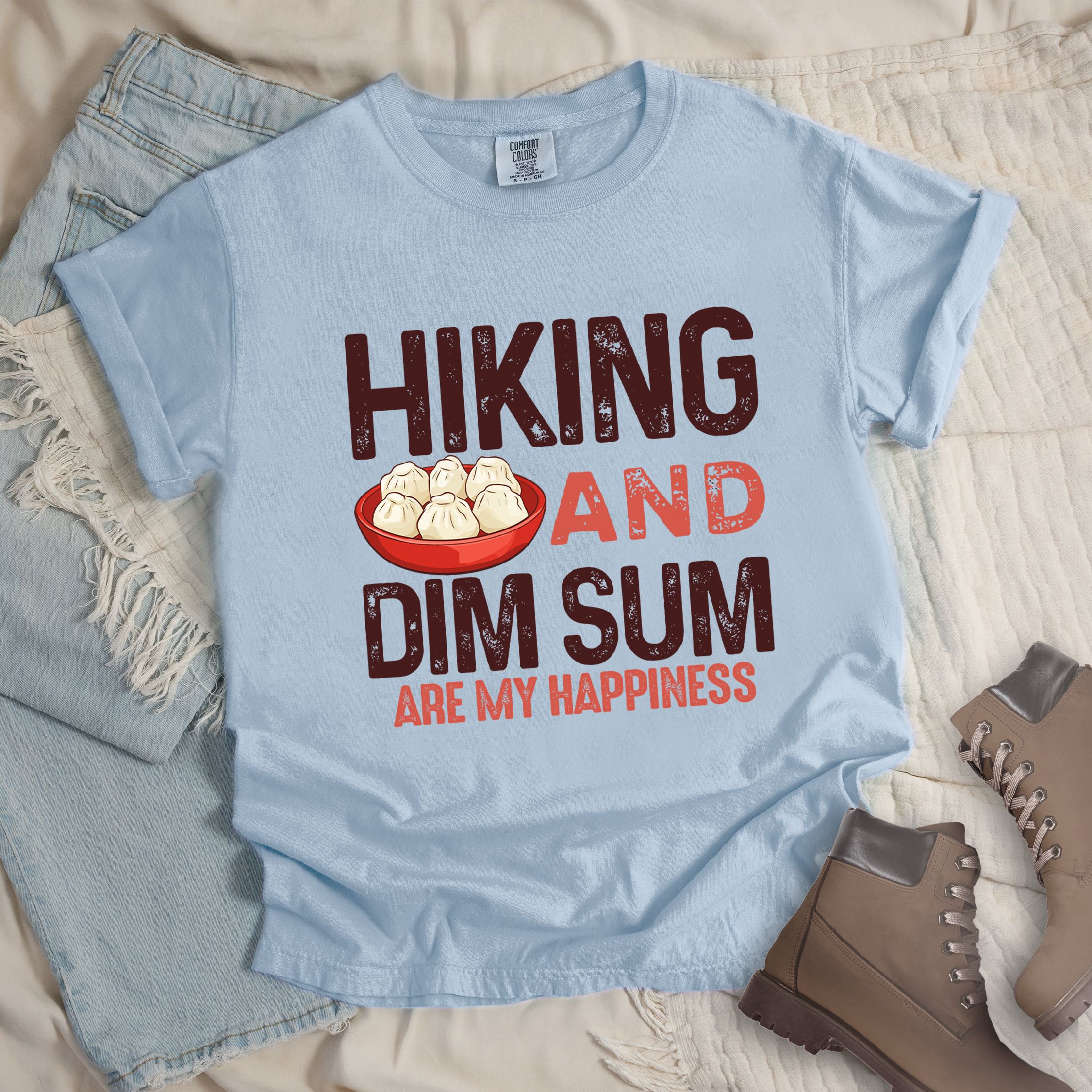Light blue shirt with Hiking Design featuring the phrase “Hiking and Dim Sum Are My Happiness” and an illustration of steamed dim sum in a red bowl.