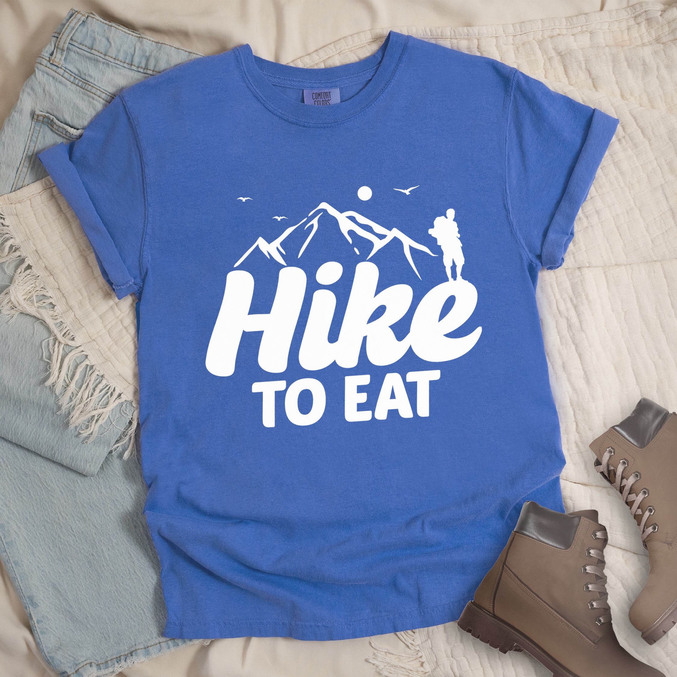 Blue shirt with Hiking Design featuring the phrase “Hike To Eat” showing a hiker silhouette and mountain illustration.