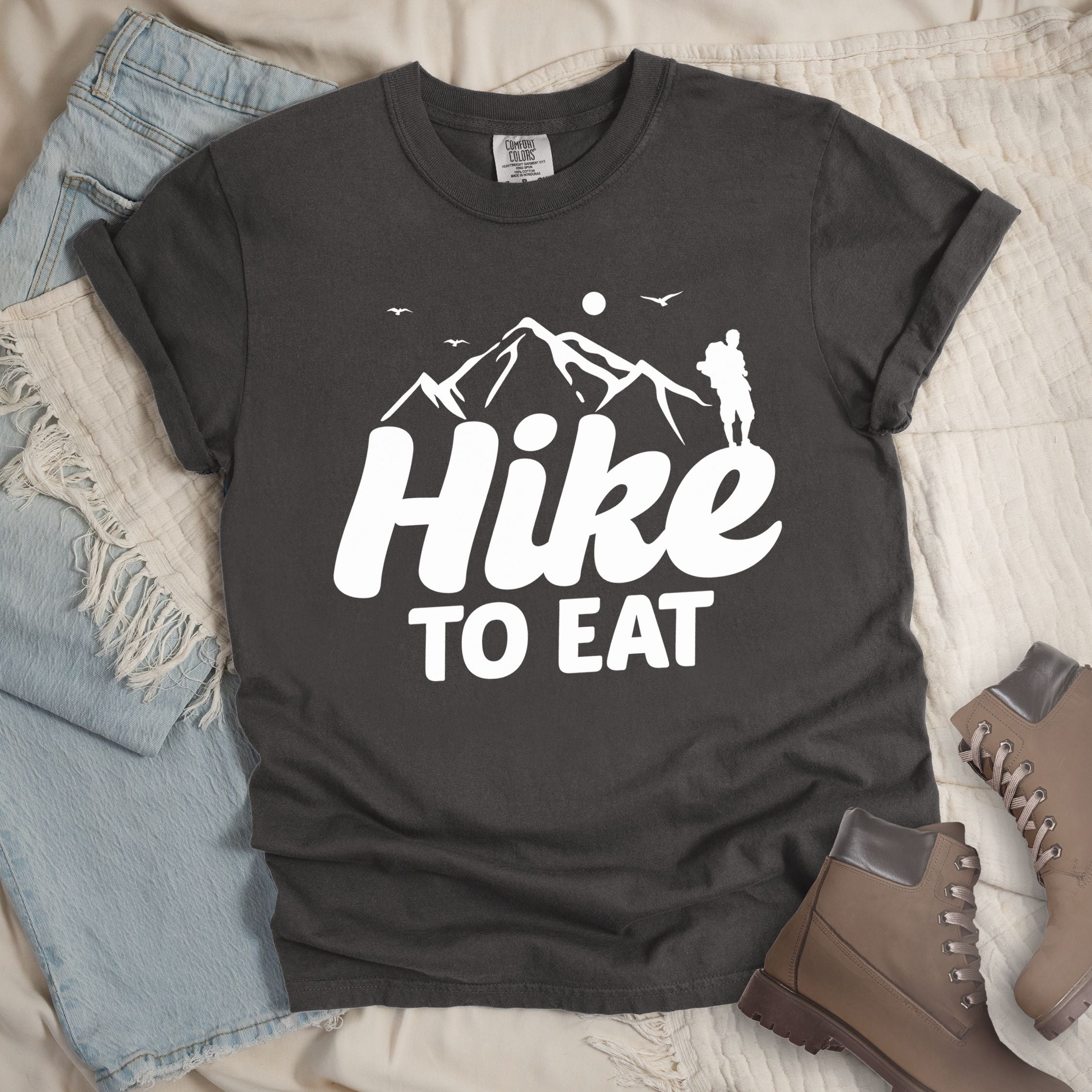 Dark grey shirt with Hiking Design featuring the phrase “Hike To Eat” showing a hiker silhouette and mountain illustration.