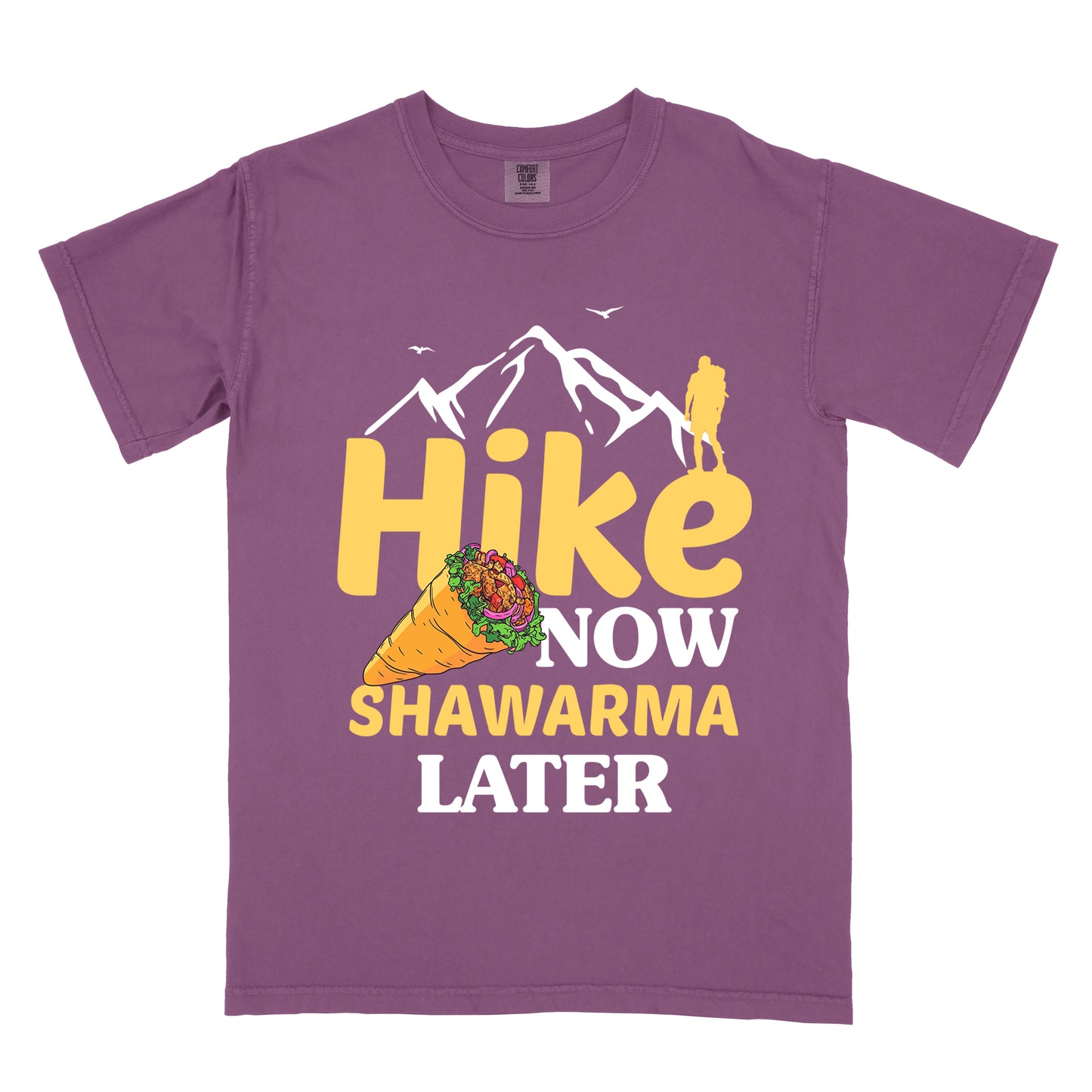 Berry (Dark Violet) t-shirt with text "HIKE NOW SHAWARMA LATER" in yellow and white lettering. A mountain silhouette appears above with a small hiker figure. The word "HIKE" is in large yellow text, "NOW" in smaller white text, "SHAWARMA" in yellow with an illustration of a shawarma wrap beside it, and "LATER" in white. The design emphasizes hiking motivation with food reward.