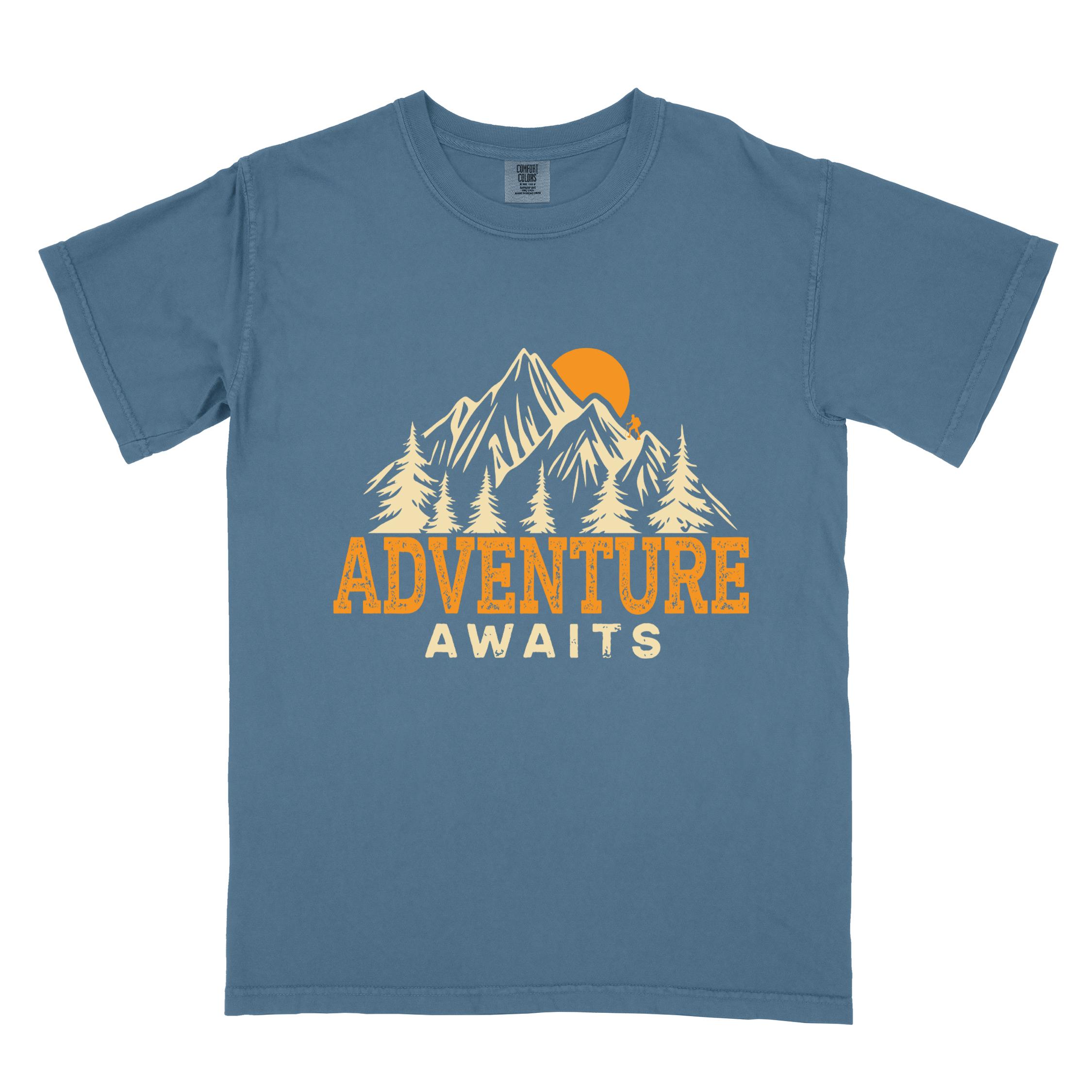 blue jean "Adventure Awaits" colored statement tee with bold typography, mountains, birds, perfect for adventure motivated individuals.