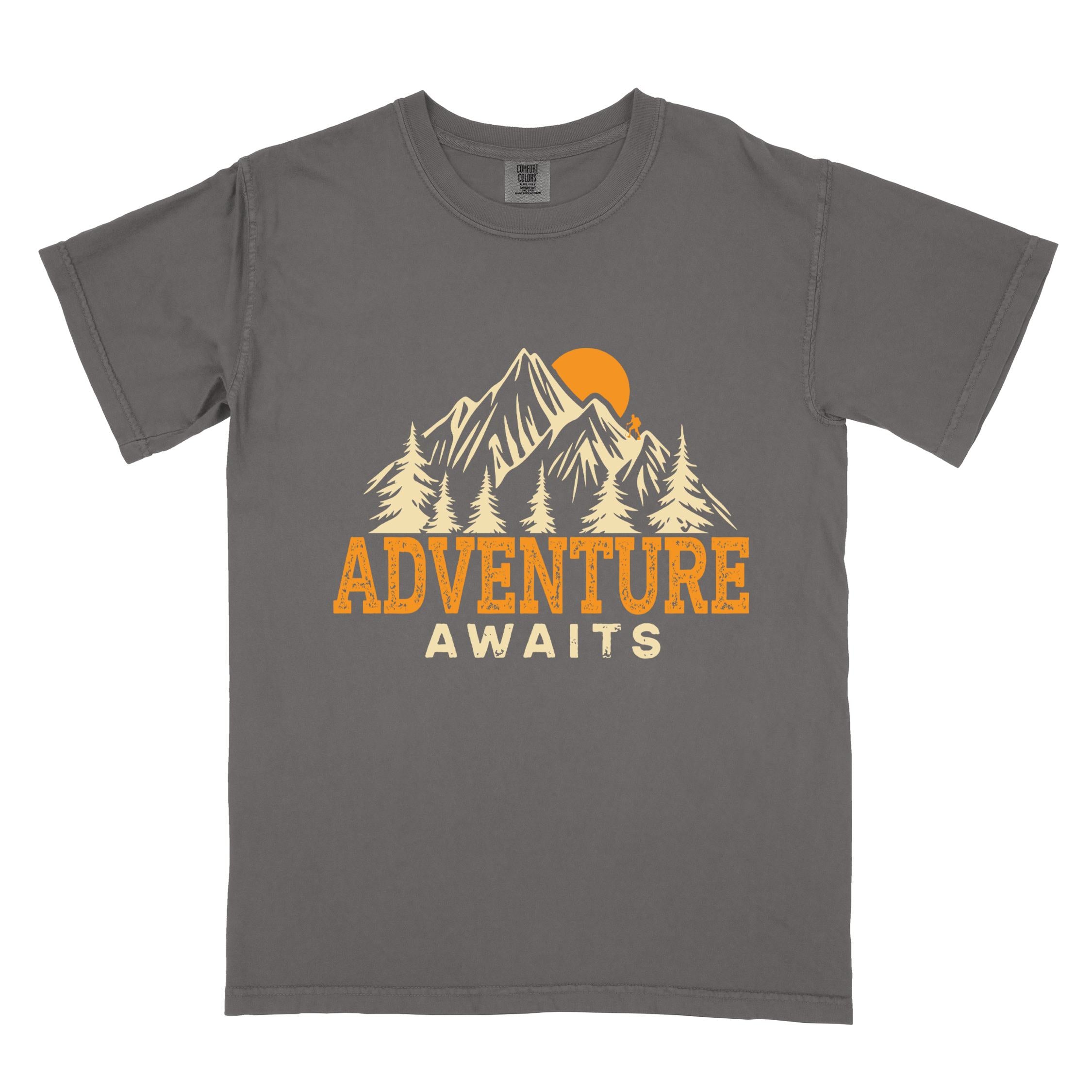 Pepper "Adventure Awaits" colored statement tee with bold typography, mountains, birds, perfect for adventure motivated individuals.