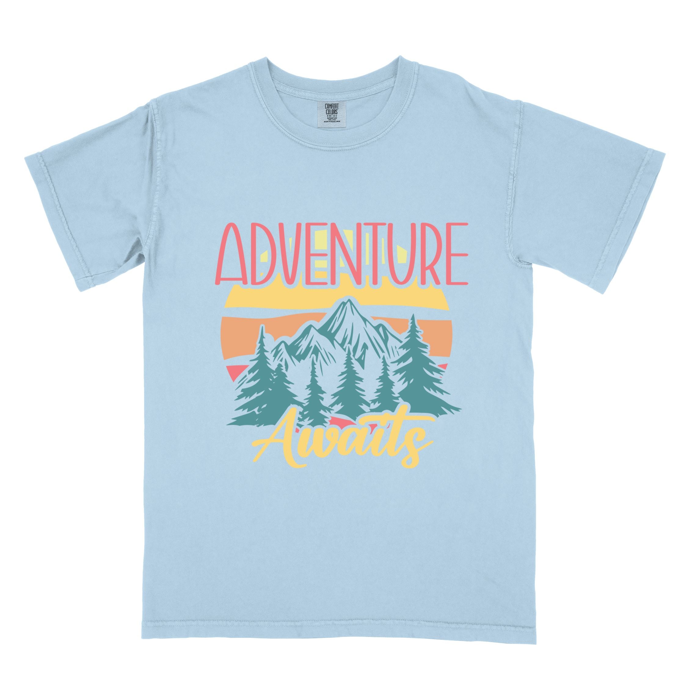 Chambray "Adventure Awaits" colored statement tee with bold typography, mountains, birds, perfect for adventure motivated individuals.