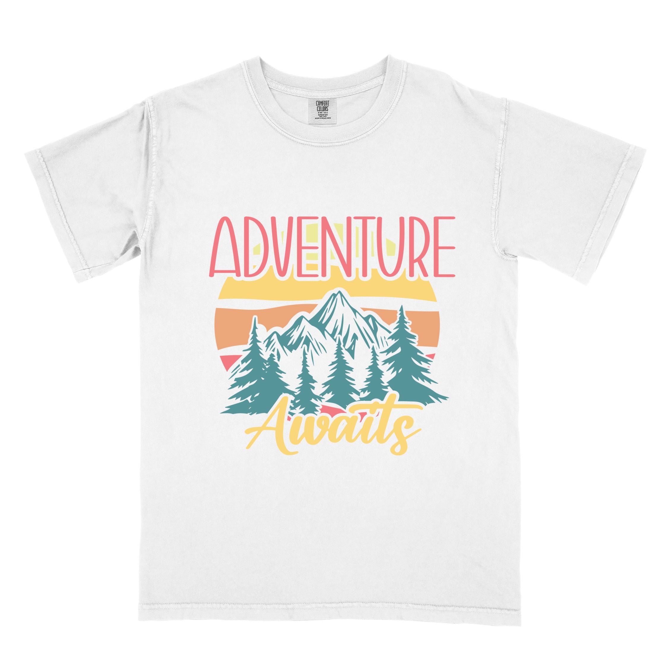 White "Adventure Awaits" colored statement tee with bold typography, mountains, birds, perfect for adventure motivated individuals.