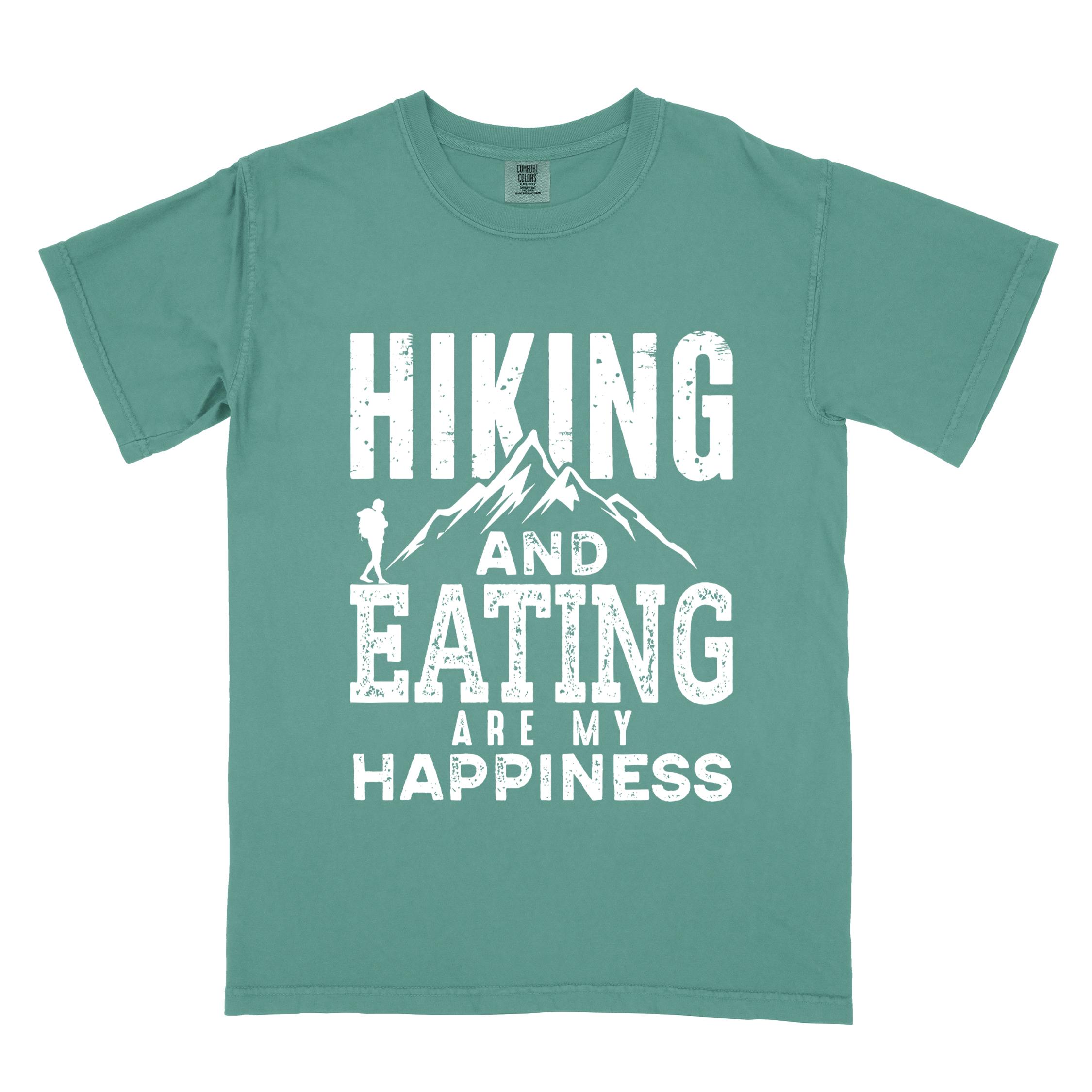 Light green "Hiking and Eating are my happiness" colored statement tee with bold typography, mountains, birds, perfect for adventure motivated individuals.