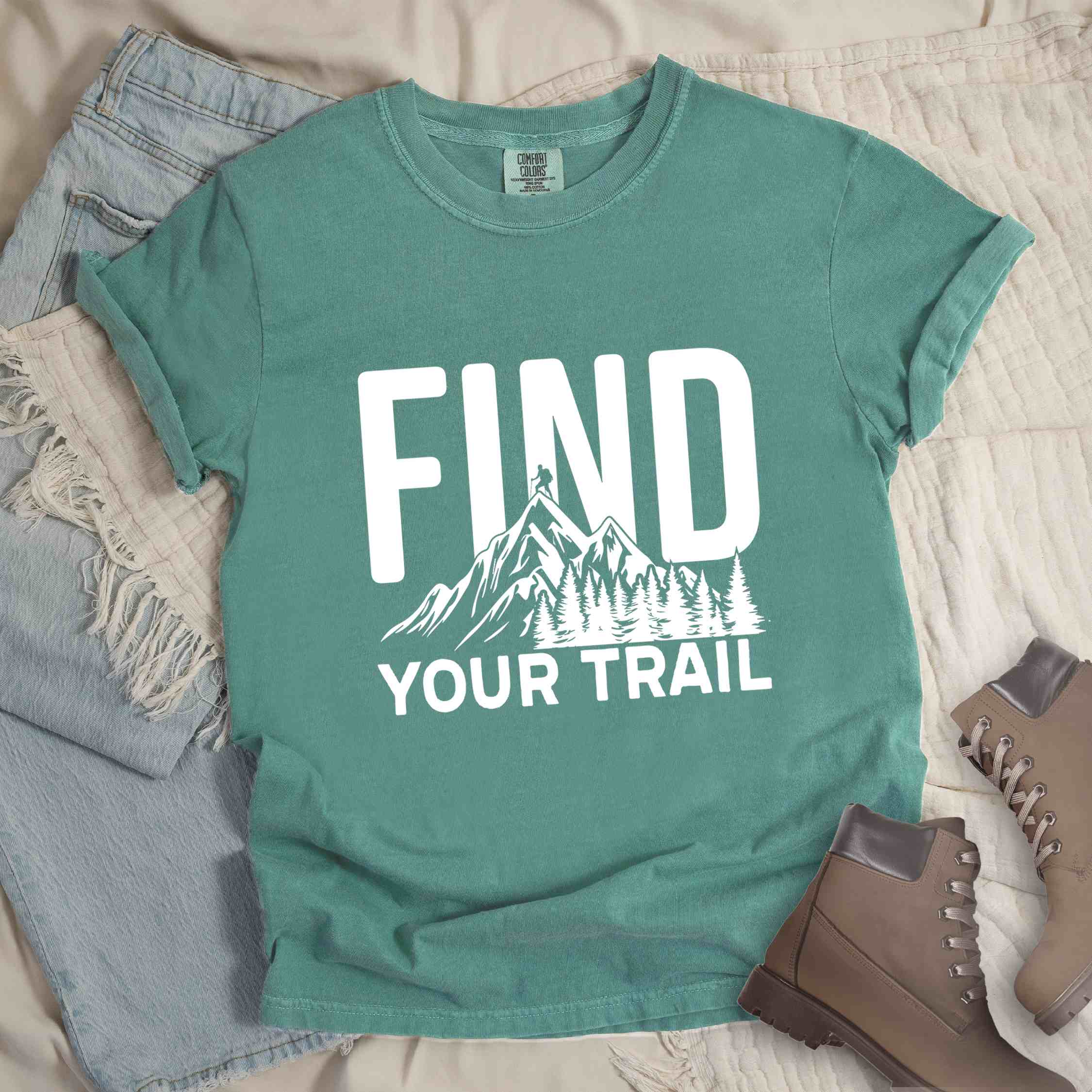 Light green "Find your trail" colored statement tee with bold typography, mountains, birds, perfect for adventure motivated individuals.