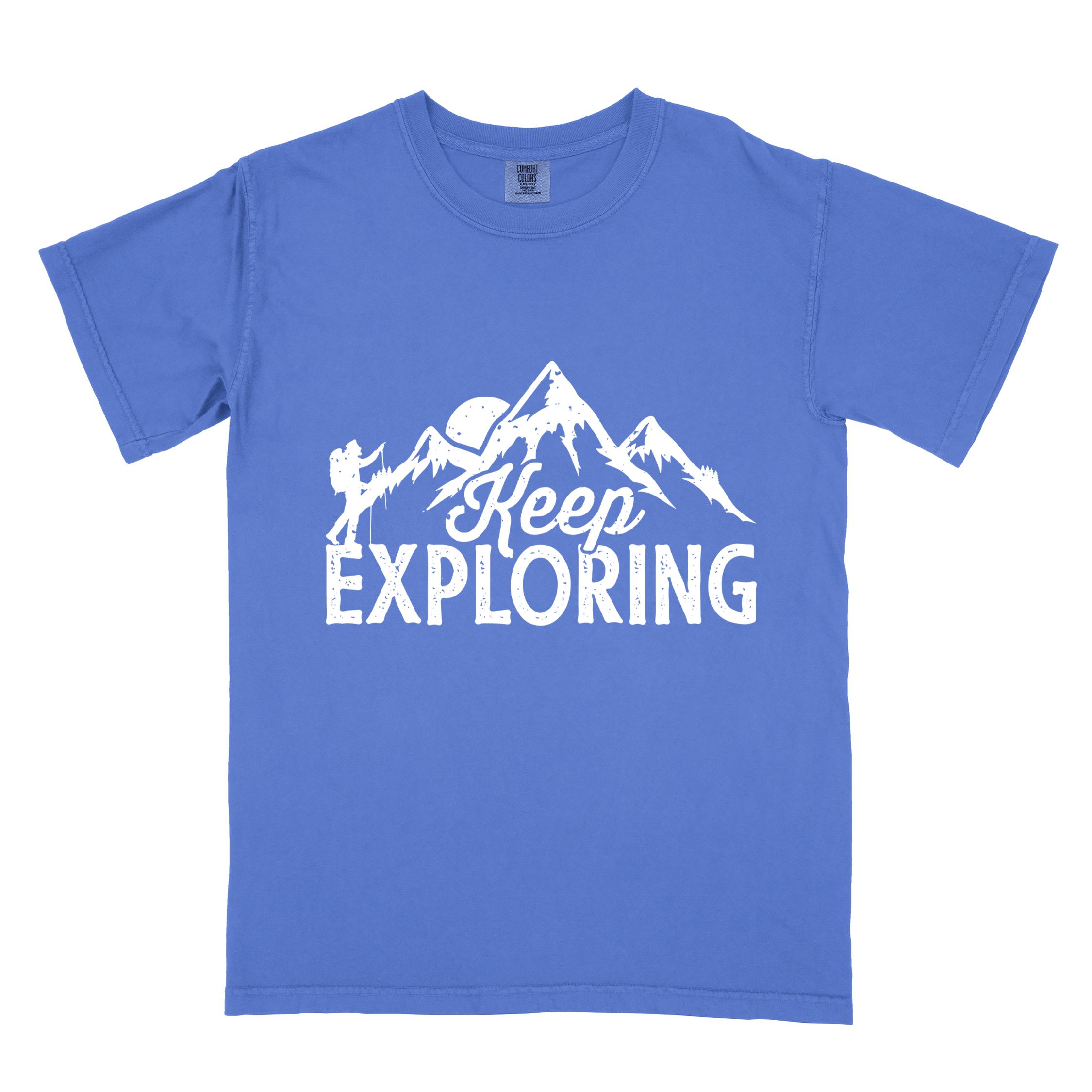 flo blue "Keep Exploring" colored statement tee with bold typography, mountains, birds, perfect for adventure motivated individuals.
