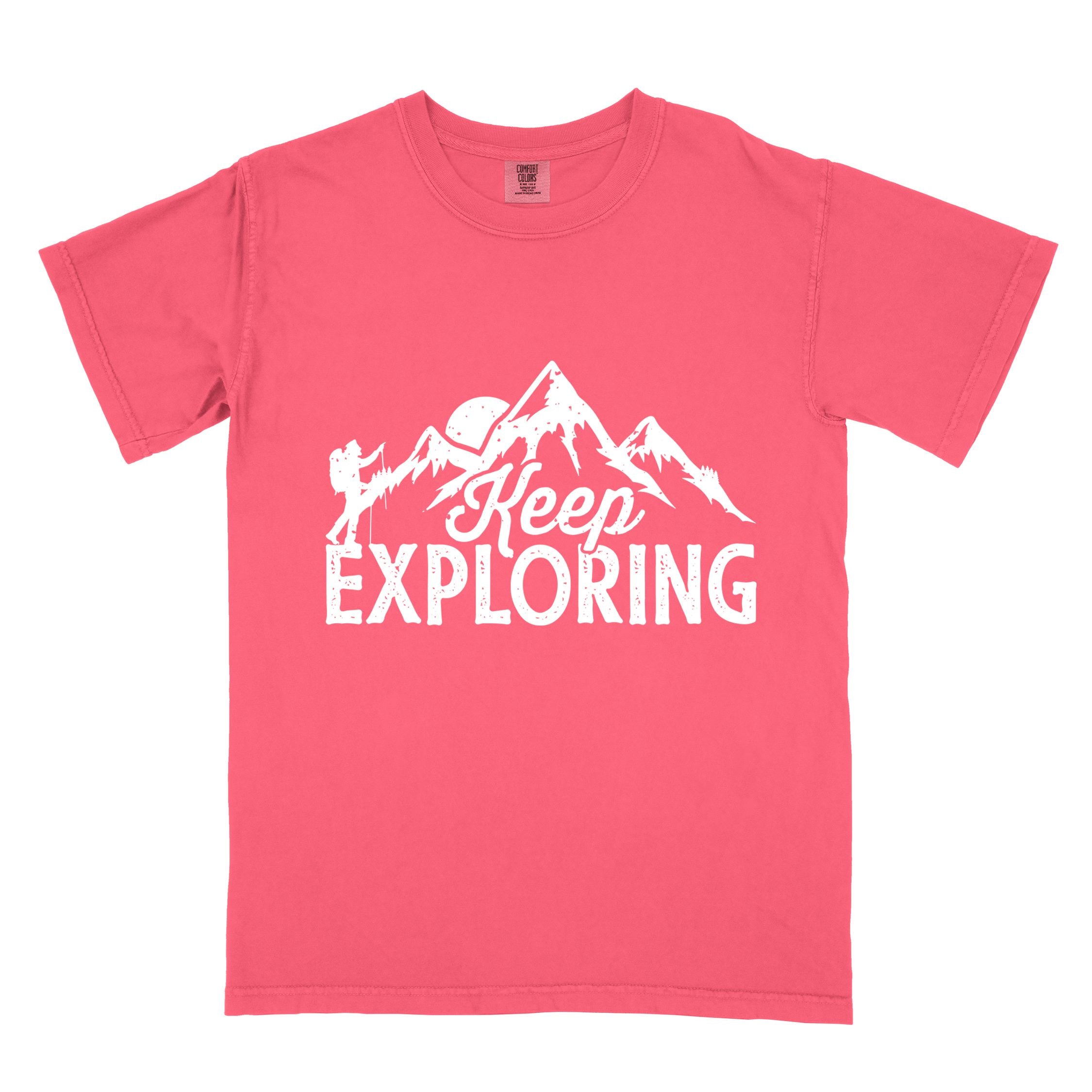 Watermelon "Keep Exploring" colored statement tee with bold typography, mountains, birds, perfect for adventure motivated individuals.