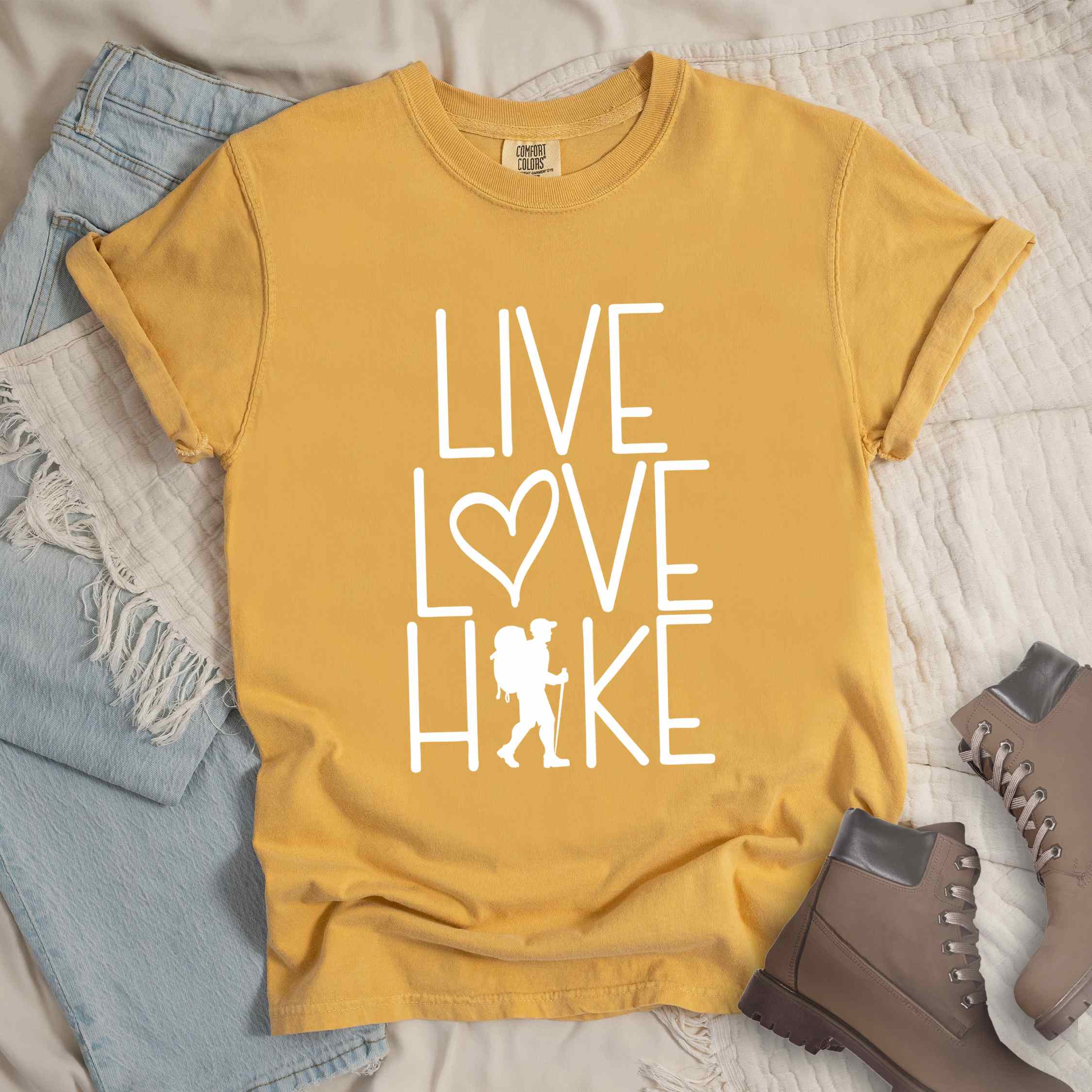Mustard "Live Love hike" colored statement tee with bold typography, perfect for adventure motivated individuals.