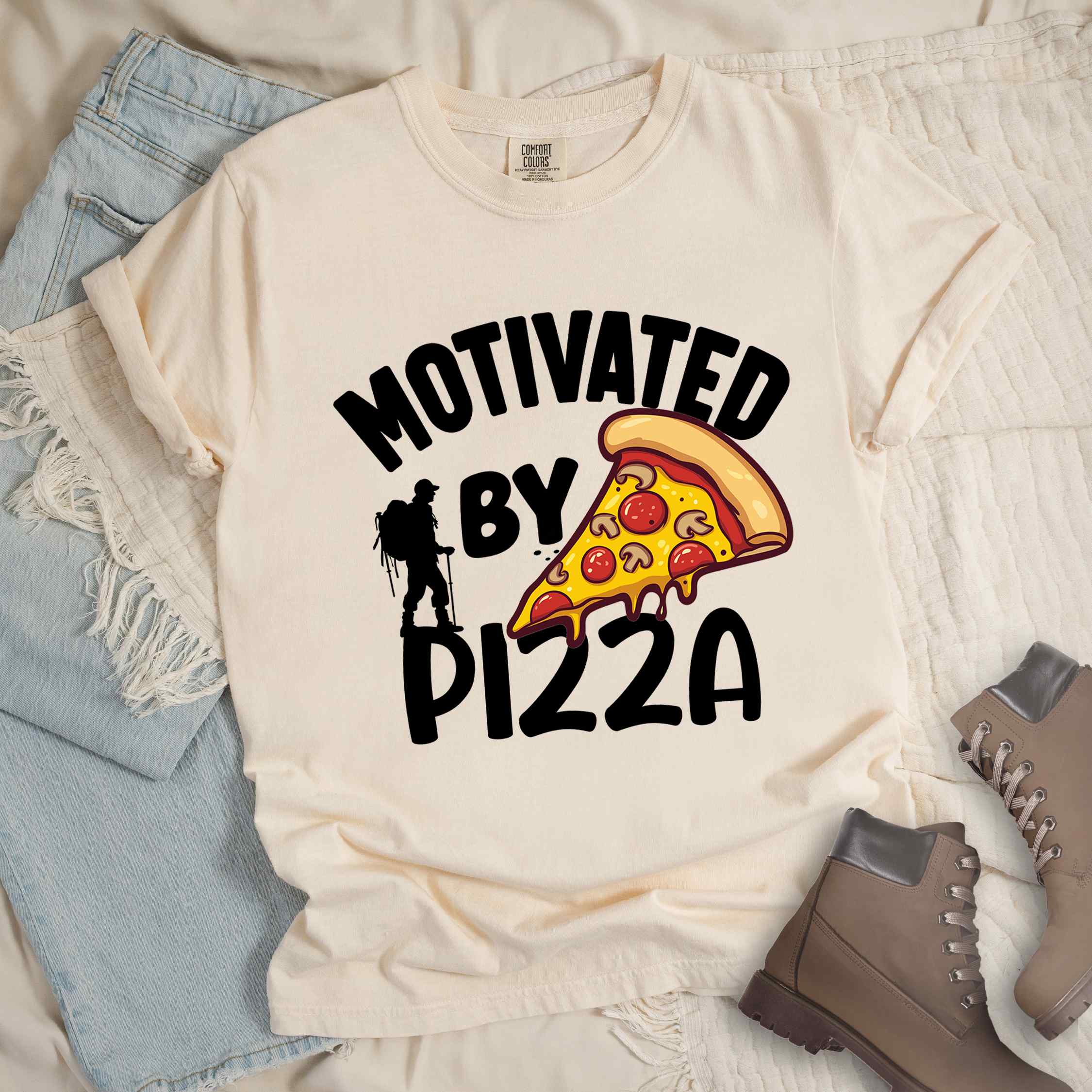 Ivory Motivated by Pizza colored vintage tee with bold typography, illustrated pizza slice, and backpacker for foodies.