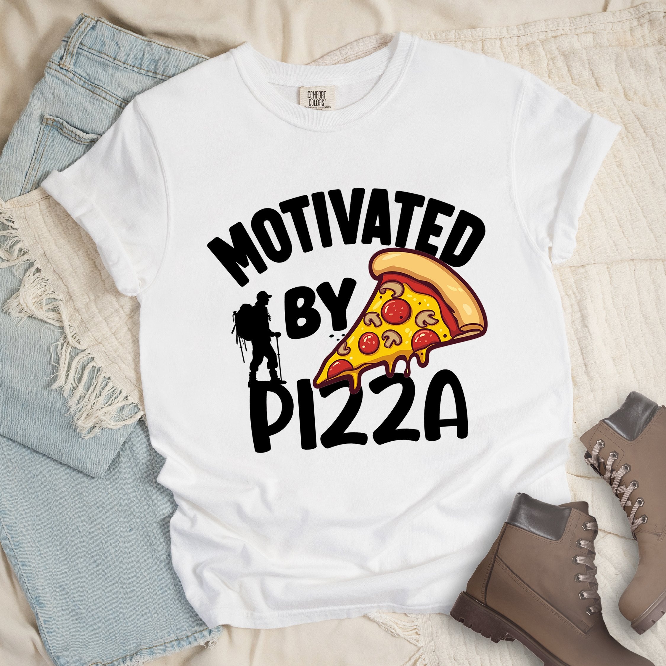 White shirt showing a hiking design with 'Motivated By Pizza' phrase and an illustration of a slice of pizza
