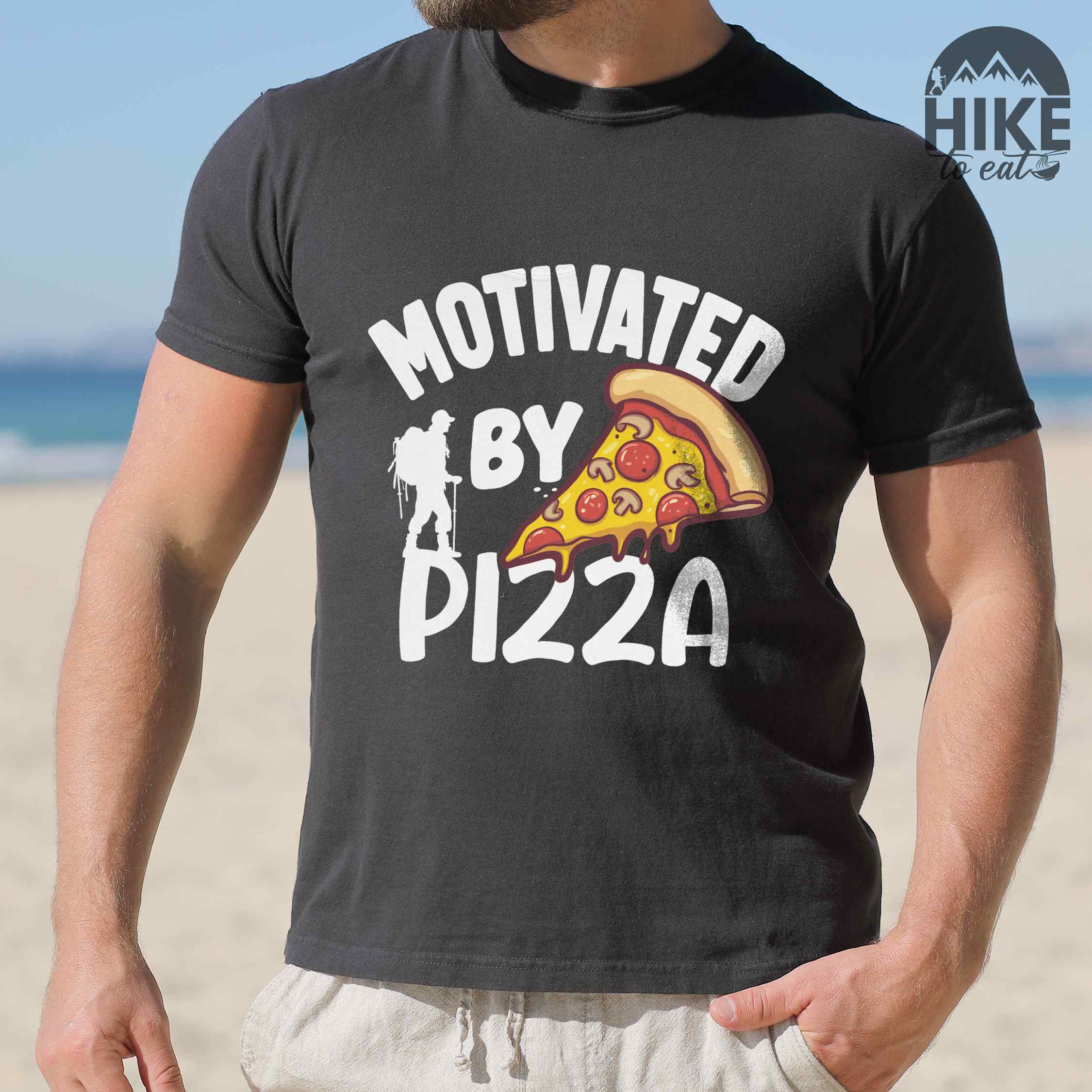 Man wearing black Motivated by Pizza colored vintage tee with bold typography, illustrated pizza slice, and backpacker for foodies.