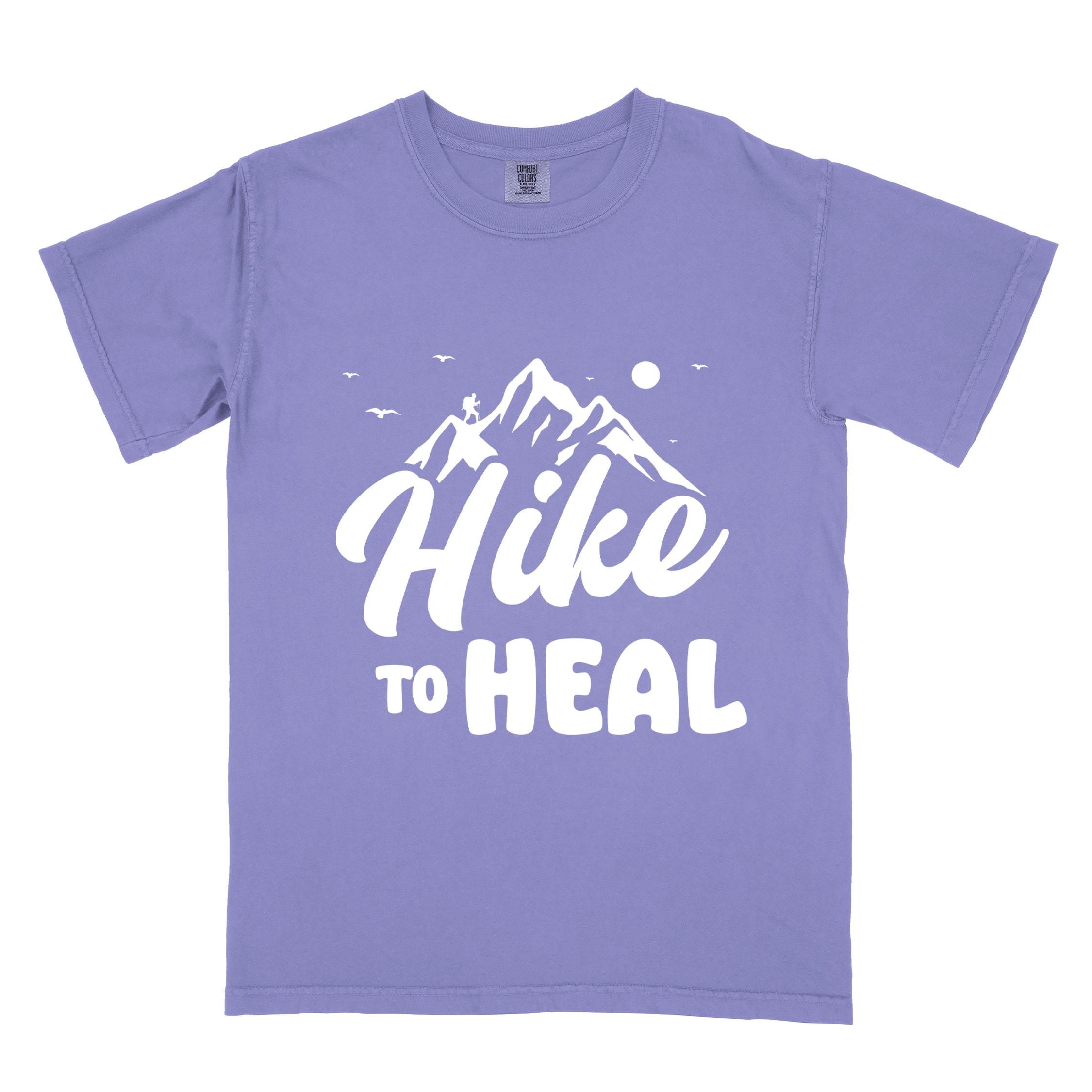 Violet "Hike to Heal" colored statement tee with bold typography, mountain, sunrise, perfect for adventure driven individuals.