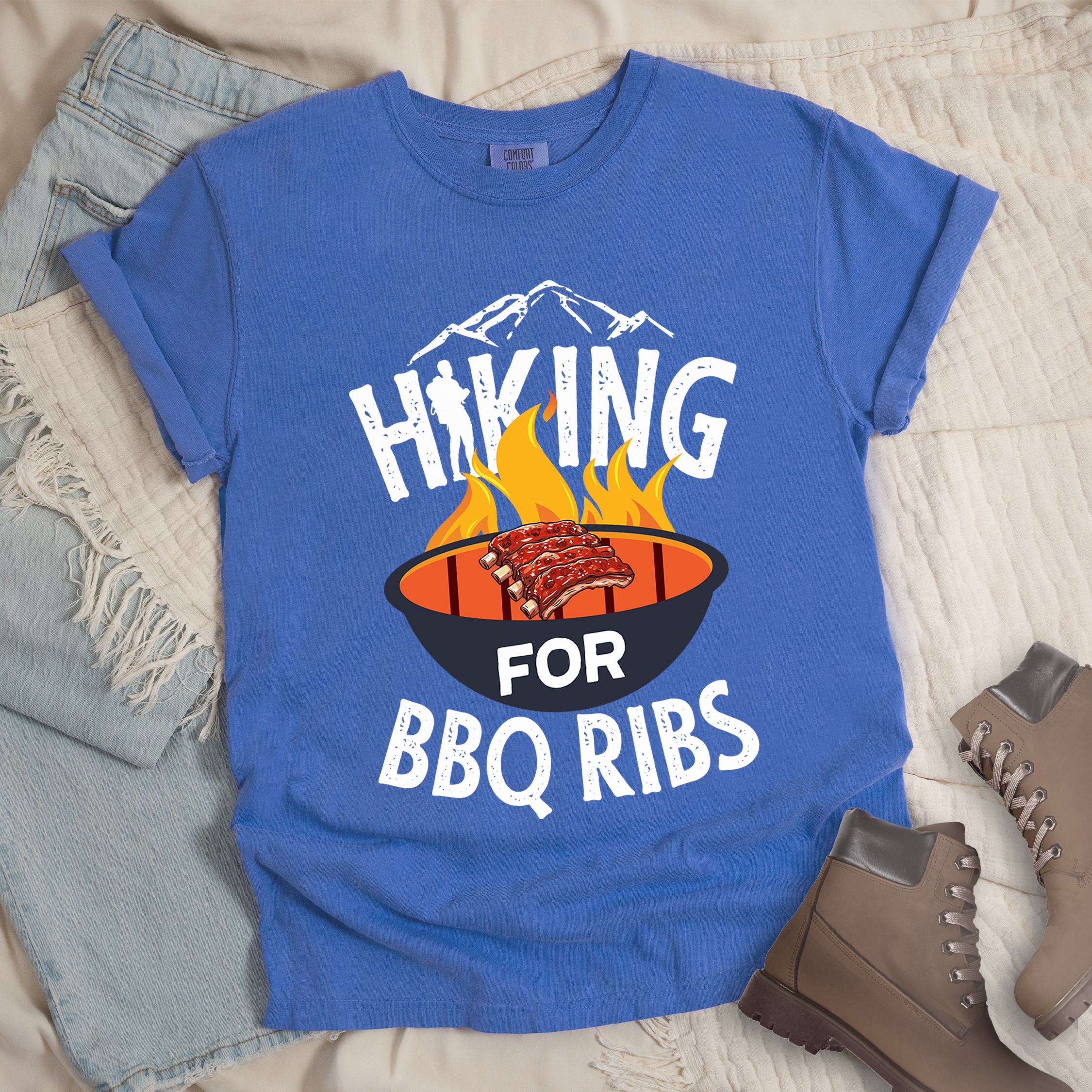 Blue shirt showing a hiking design with 'HIKING FOR BBQ RIBS' phrase and an illustration of BBQ ribs over a fired up grill