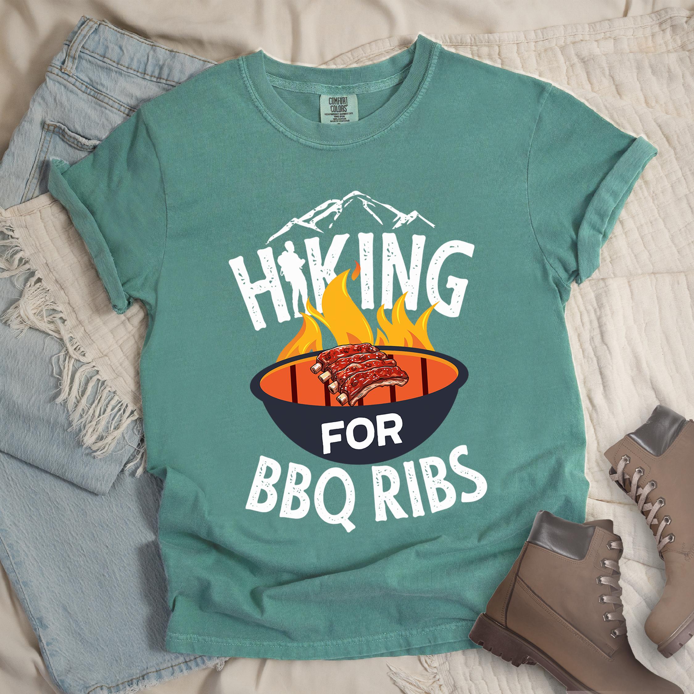 Green shirt showing a hiking design with 'HIKING FOR BBQ RIBS' phrase and an illustration of BBQ ribs over a fired up grill