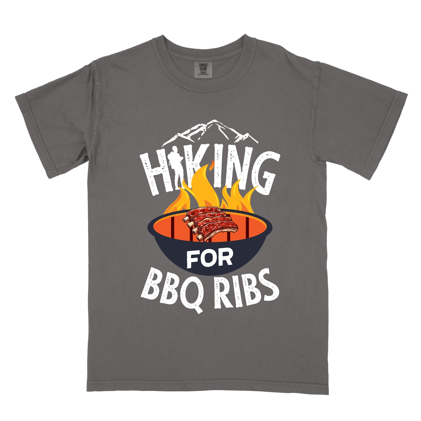 Pepper (Dark Gray) t-shirt with white distressed text reading "HIKING FOR BBQ RIBS". Mountain silhouettes appear above the word "HIKING". The letter "I" in "HIKING" features a hiker silhouette. Between "HIKING" and "BBQ RIBS" is an illustration of a grill with flames and a rack of ribs cooking. The word "FOR" appears in white on the grill.