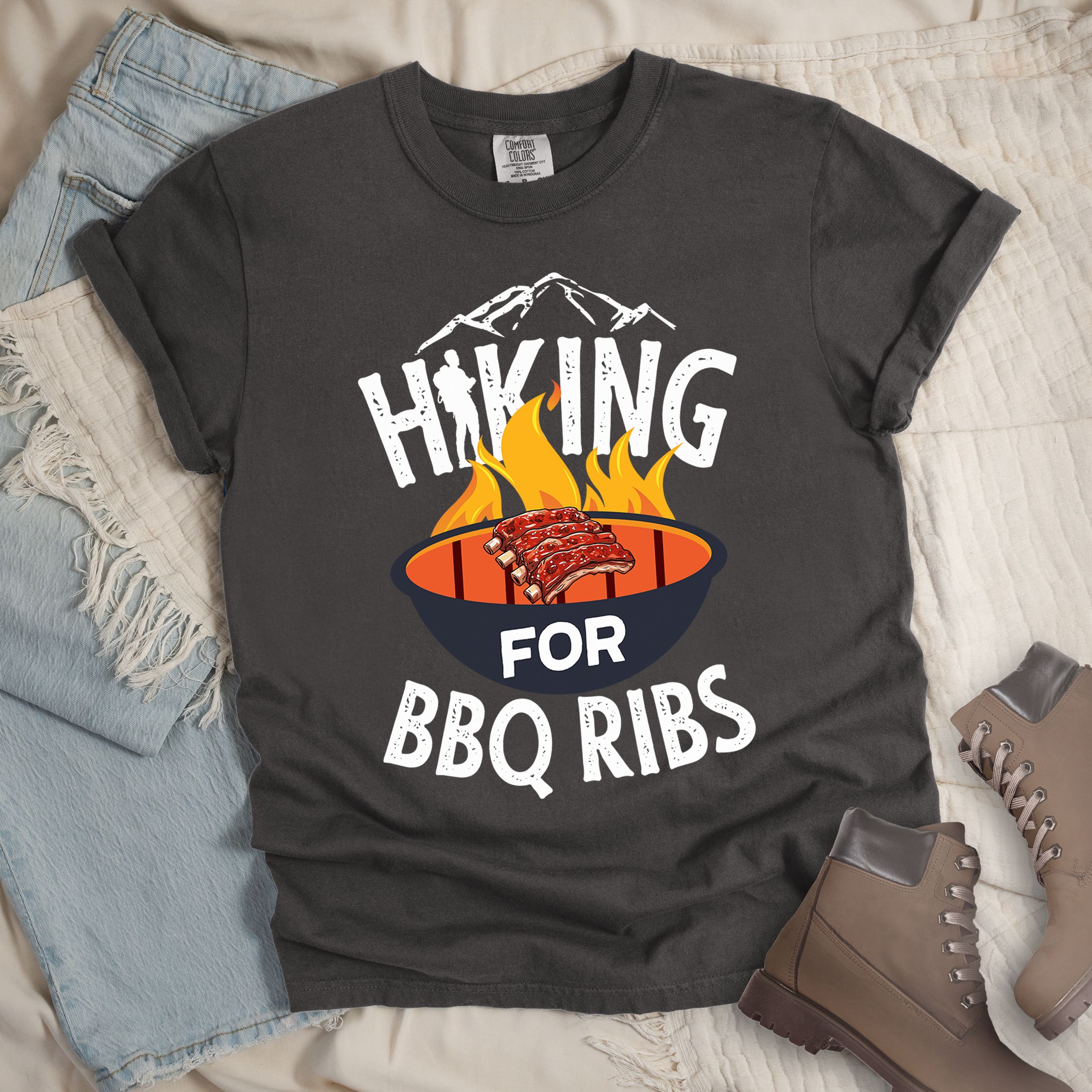 Dark grey shirt showing a hiking design with 'HIKING FOR BBQ RIBS' phrase and an illustration of BBQ ribs over a fired up grill