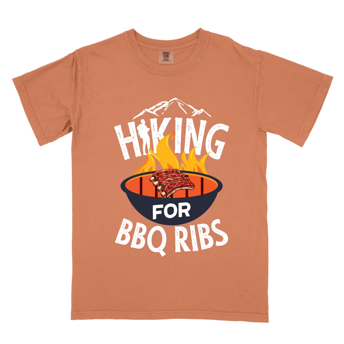 Yam (Brown) t-shirt with white distressed text reading "HIKING FOR BBQ RIBS". Mountain silhouettes appear above the word "HIKING". The letter "I" in "HIKING" features a hiker silhouette. Between "HIKING" and "BBQ RIBS" is an illustration of a grill with flames and a rack of ribs cooking. The word "FOR" appears in white on the grill.