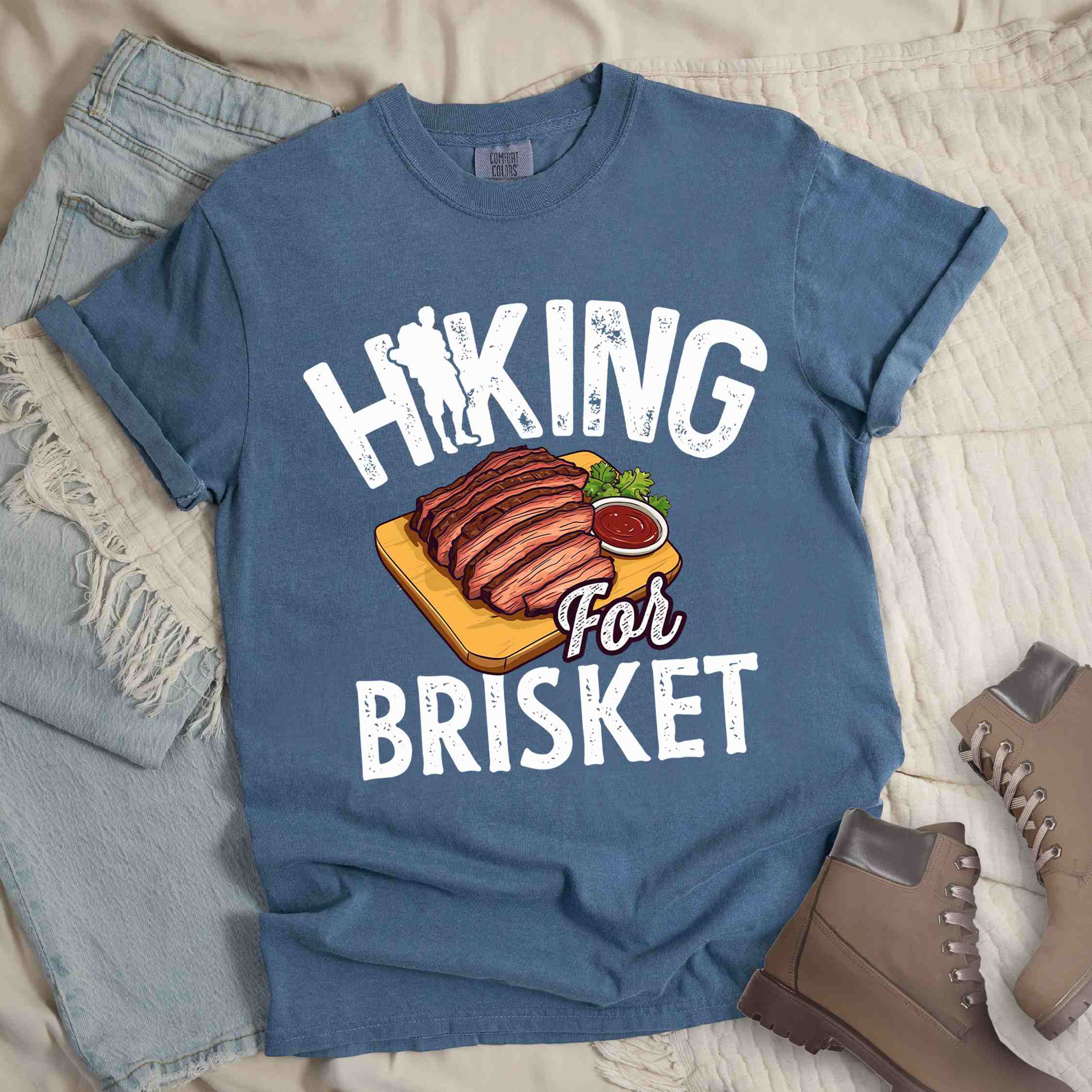 Blue jean Hiking for brisket colored vintage tee with bold typography, illustrated sliced brisket, birds, and backpacker for brisket lovers
