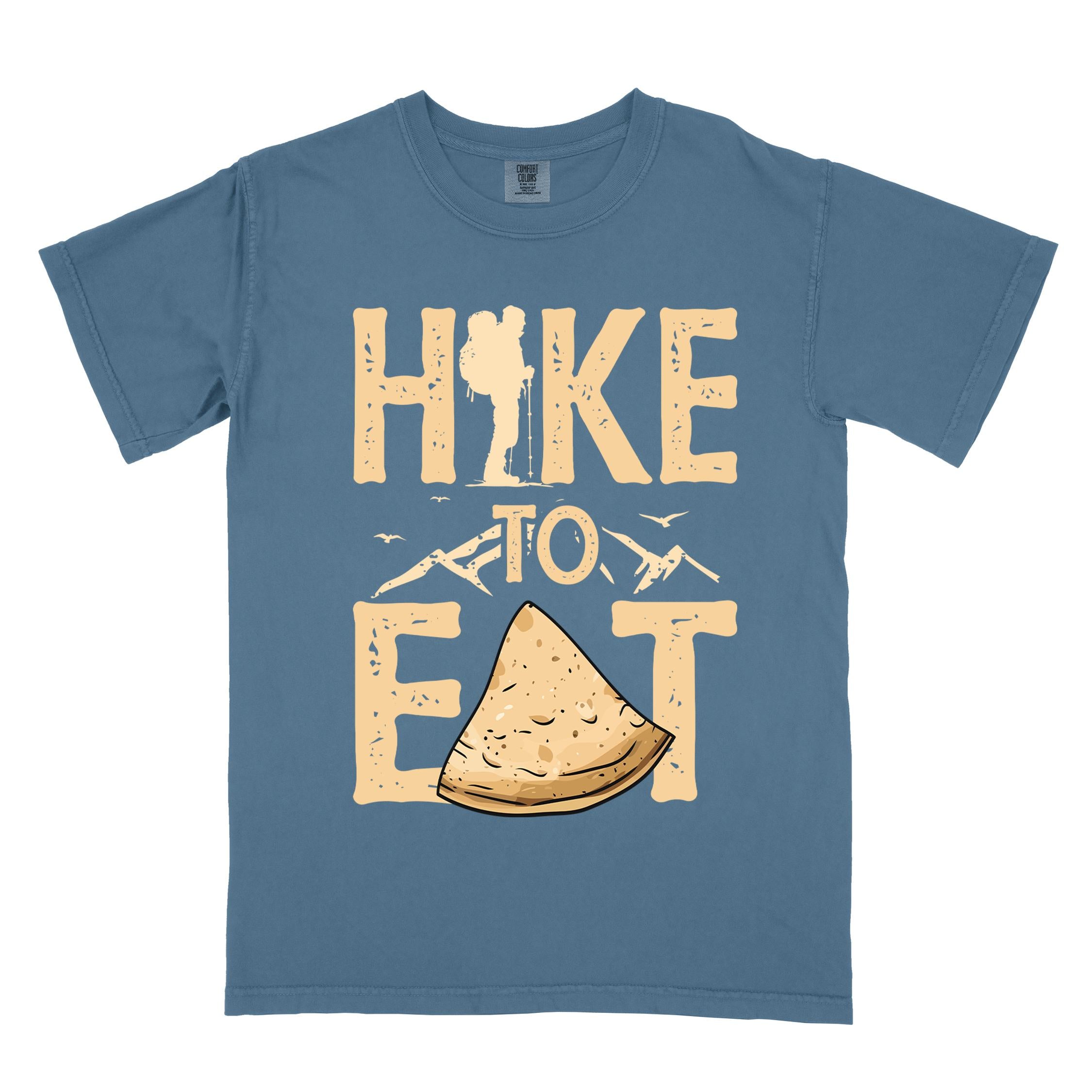 blue jean "Hike to Eat" colored statement tee with bold typography, mountain, illustrated tortilla, perfect for tortilla lovers.