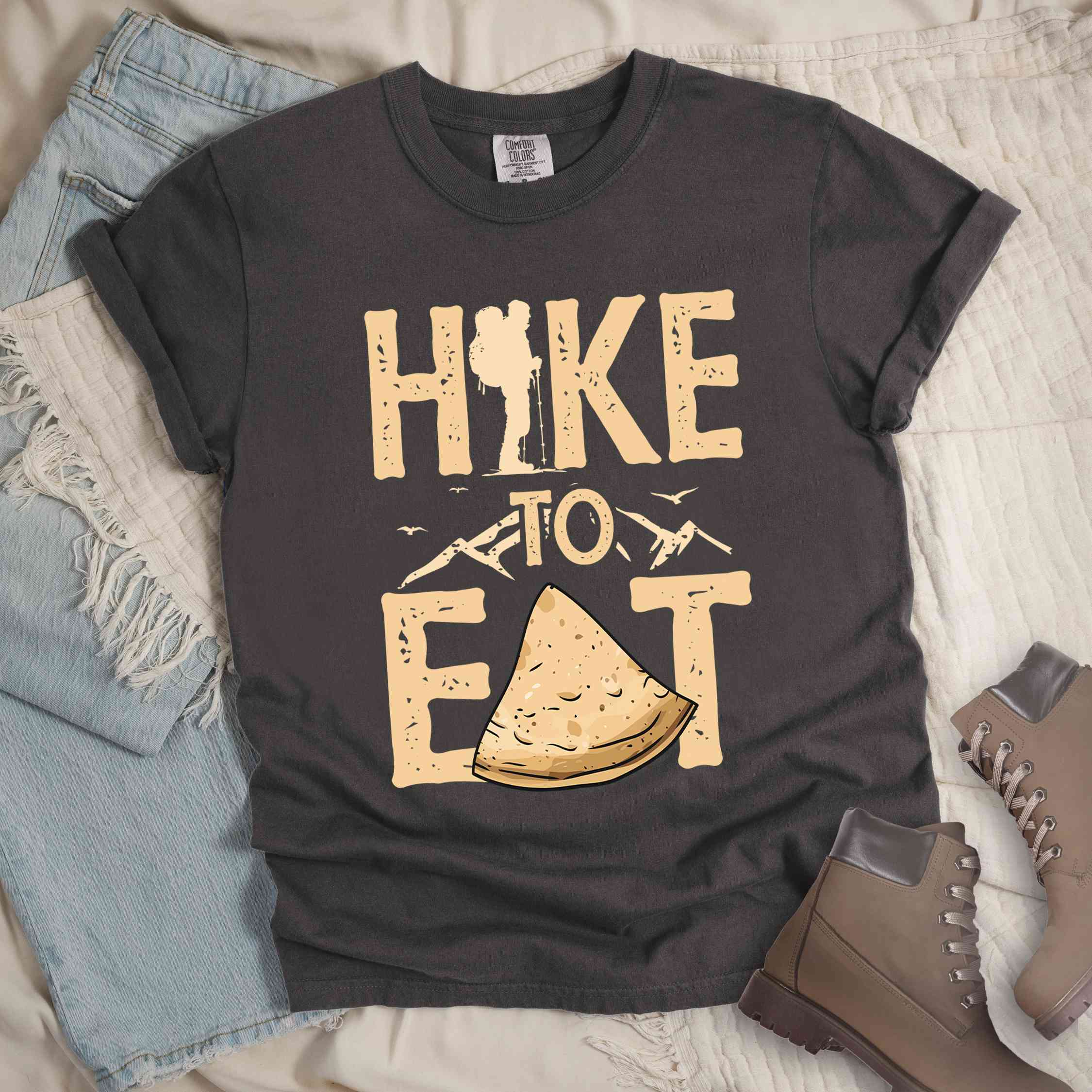 Pepper "Hike to Eat" colored statement tee with bold typography, mountain, illustrated tortilla, perfect for tortilla lovers.