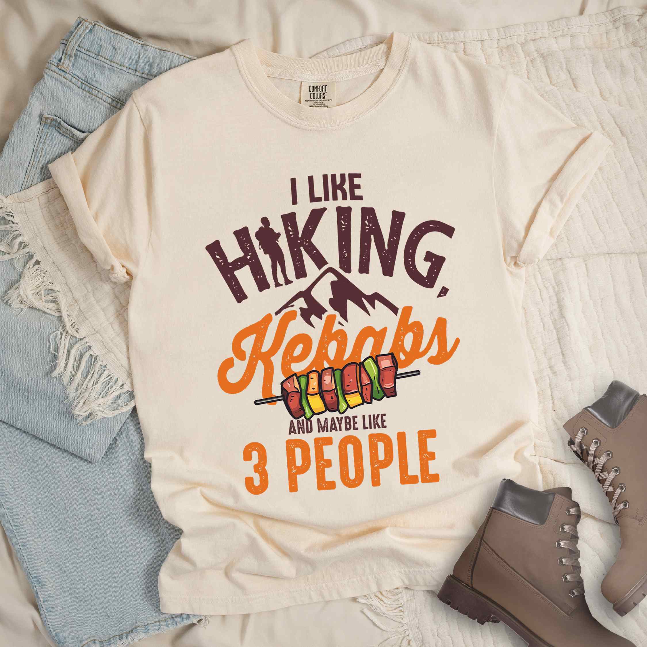 Ivory “I Like Hiking, Kebabs and Maybe Like 3 People” colored vintage tee with bold text, mountain, Illustration of grilled kebab. Perfect tee for foodie craving for grilled kebabs,