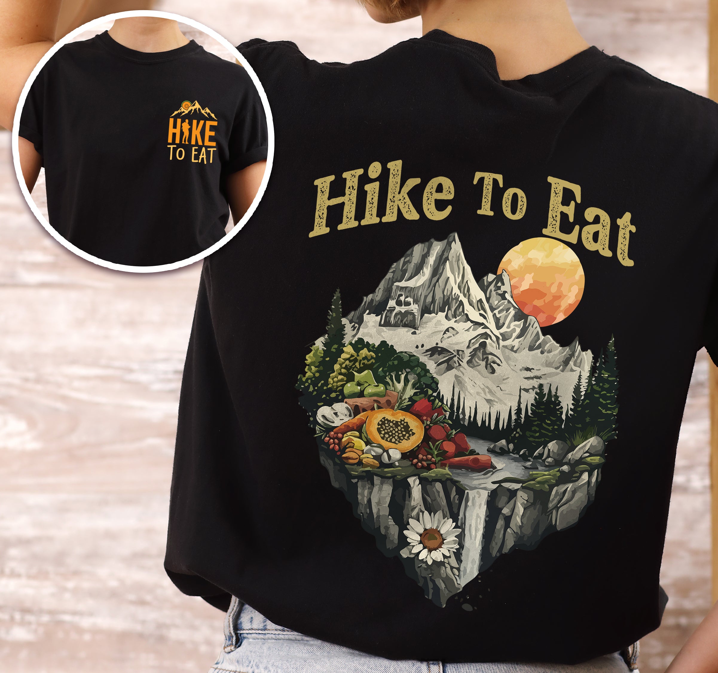 Black Hike to Eat t-shirt front and back view showing small chest logo and large back design featuring mountain landscape with waterfall and fresh food display including fruits and vegetables.