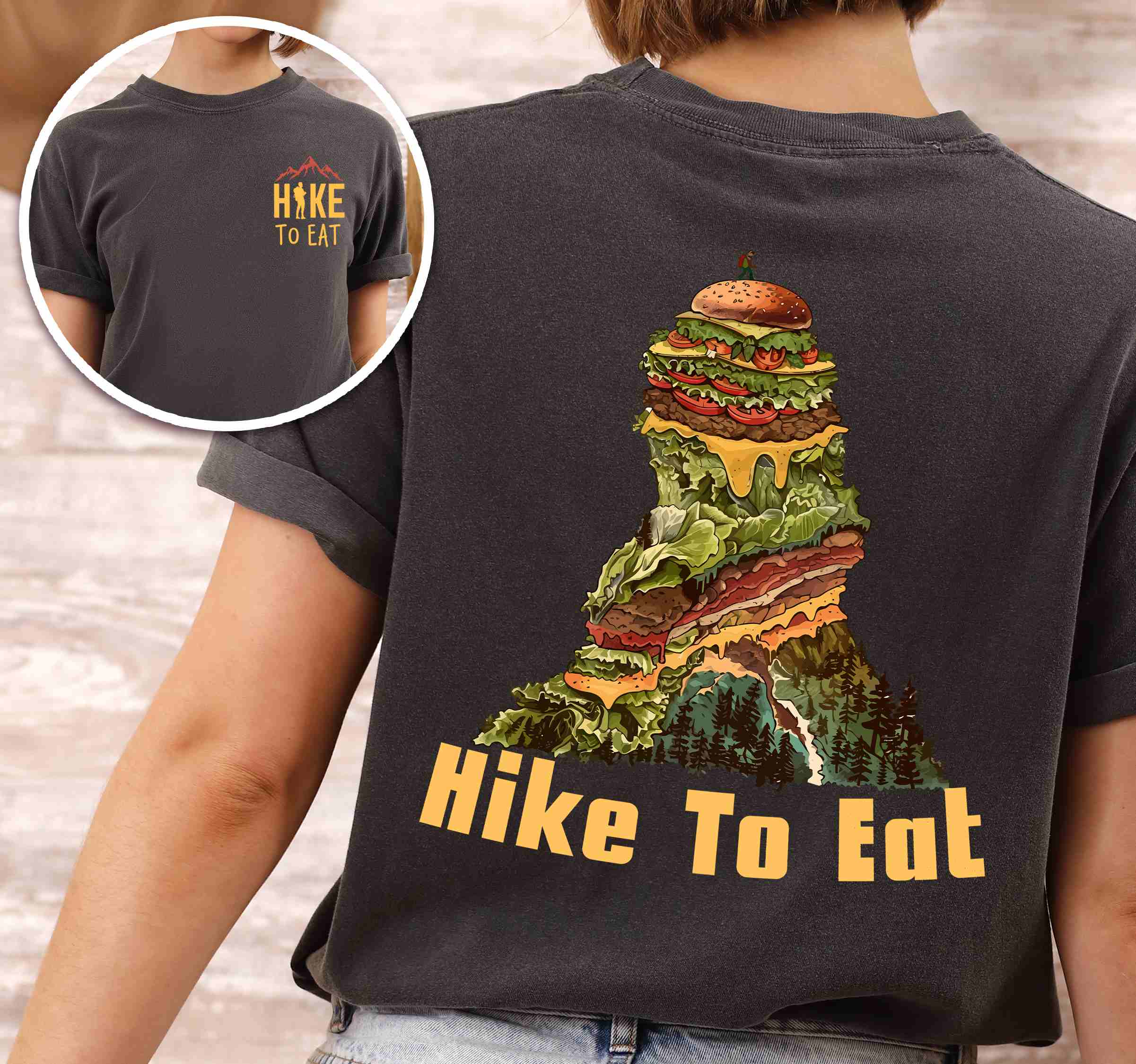 Woman wearing pepper "Hike to Eat" text in bold lettering front and back design, mountains, birds, illustrated stack of cheeseburger, and backpacker for burger lovers.