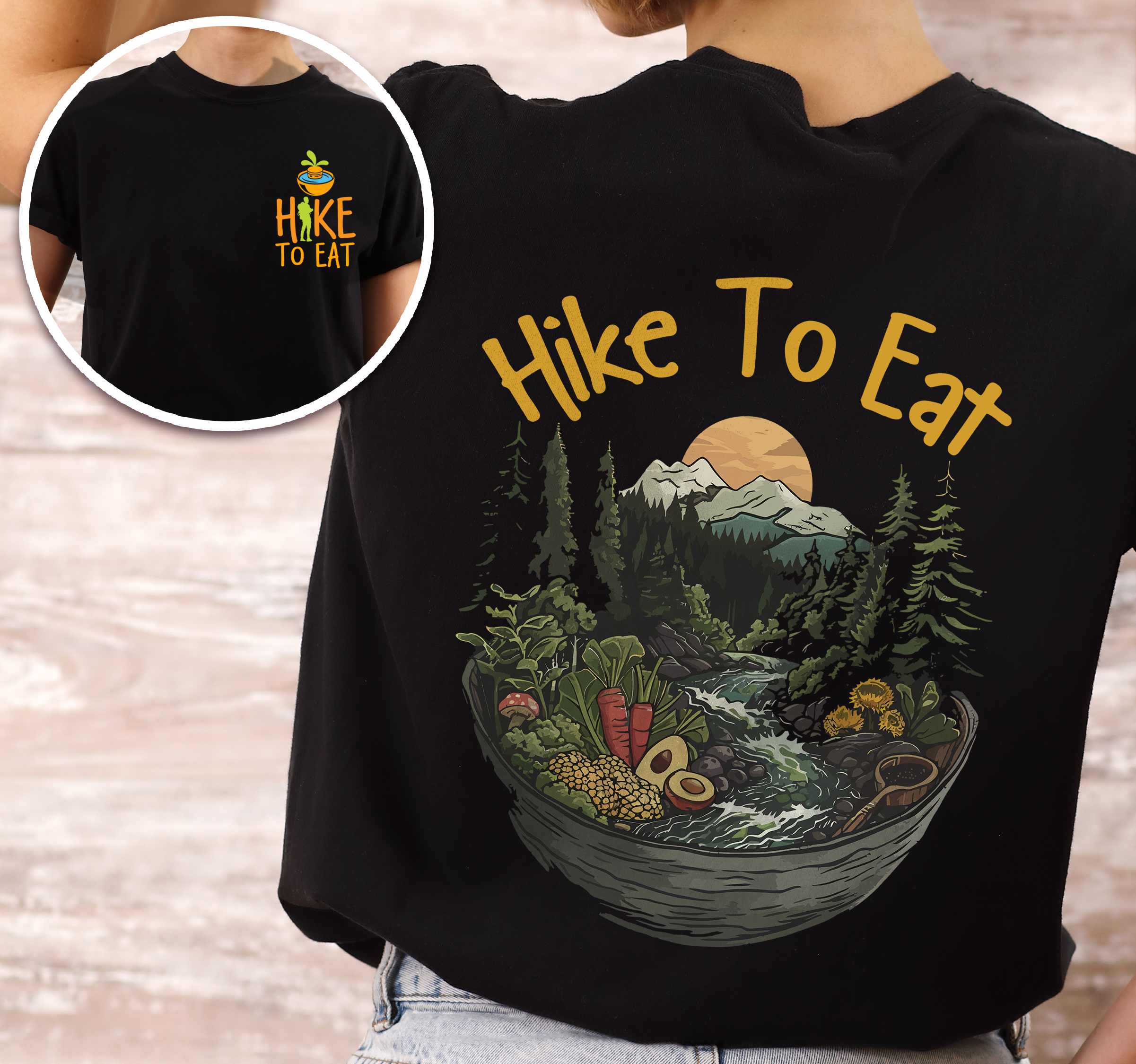 Woman wearing black "Hike to Eat" text in bold lettering front and back design, mountains, birds, illustrated bowl of mixed vegetable, and backpacker for salad lovers.